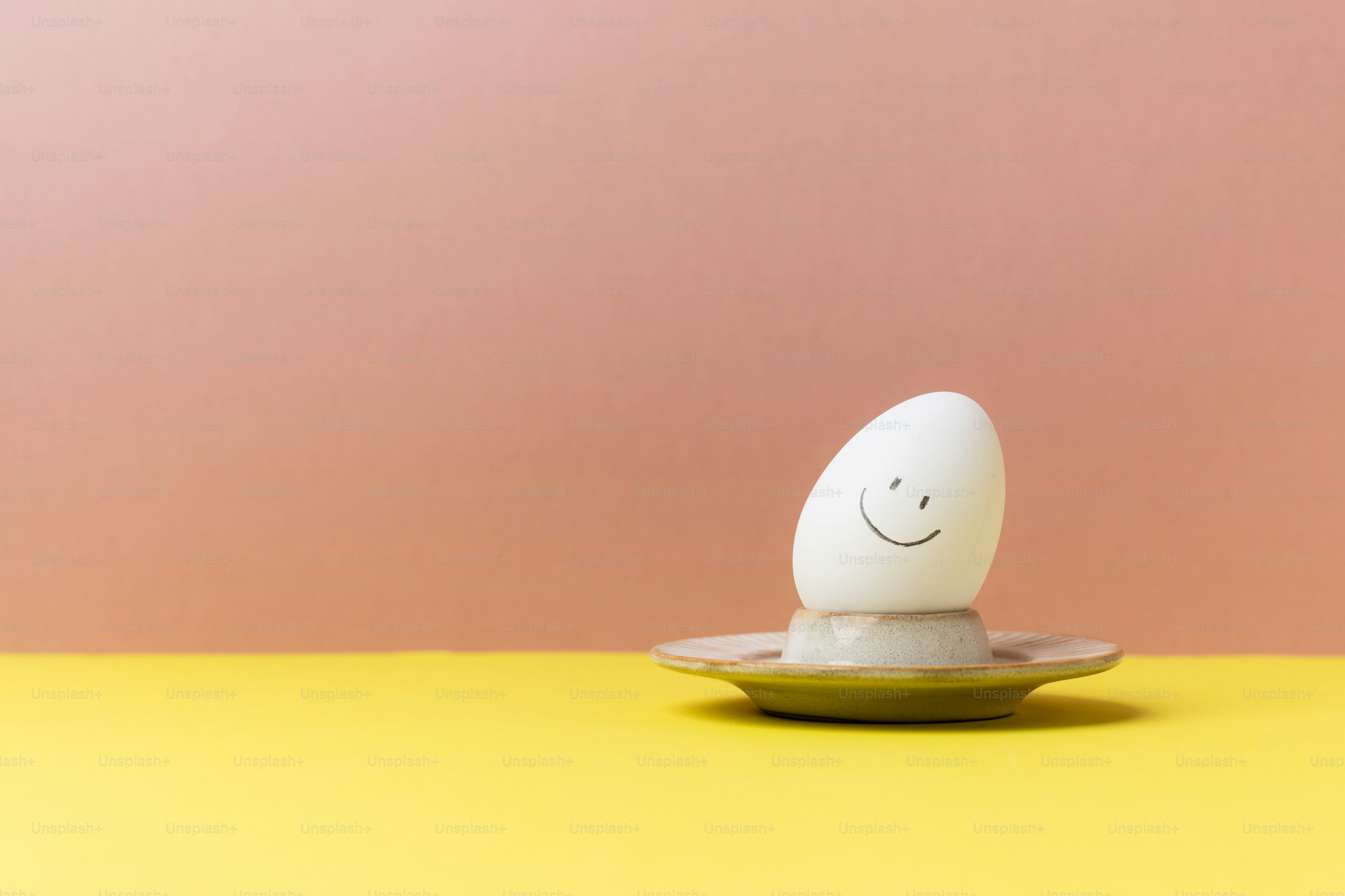 Un huevo sonriente está en una jarra de huevo.