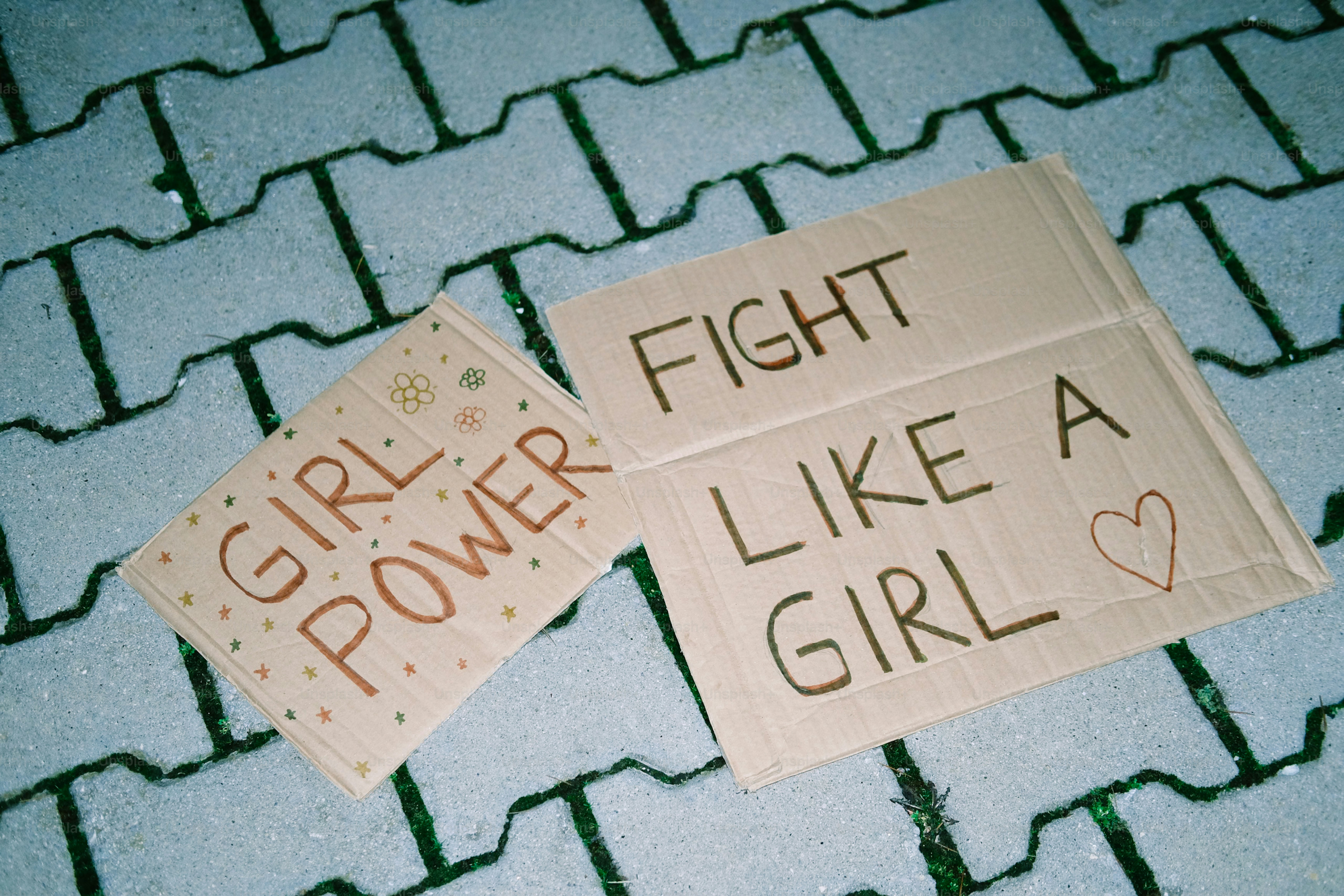 Deux panneaux avec des messages féministes sur une surface texturée