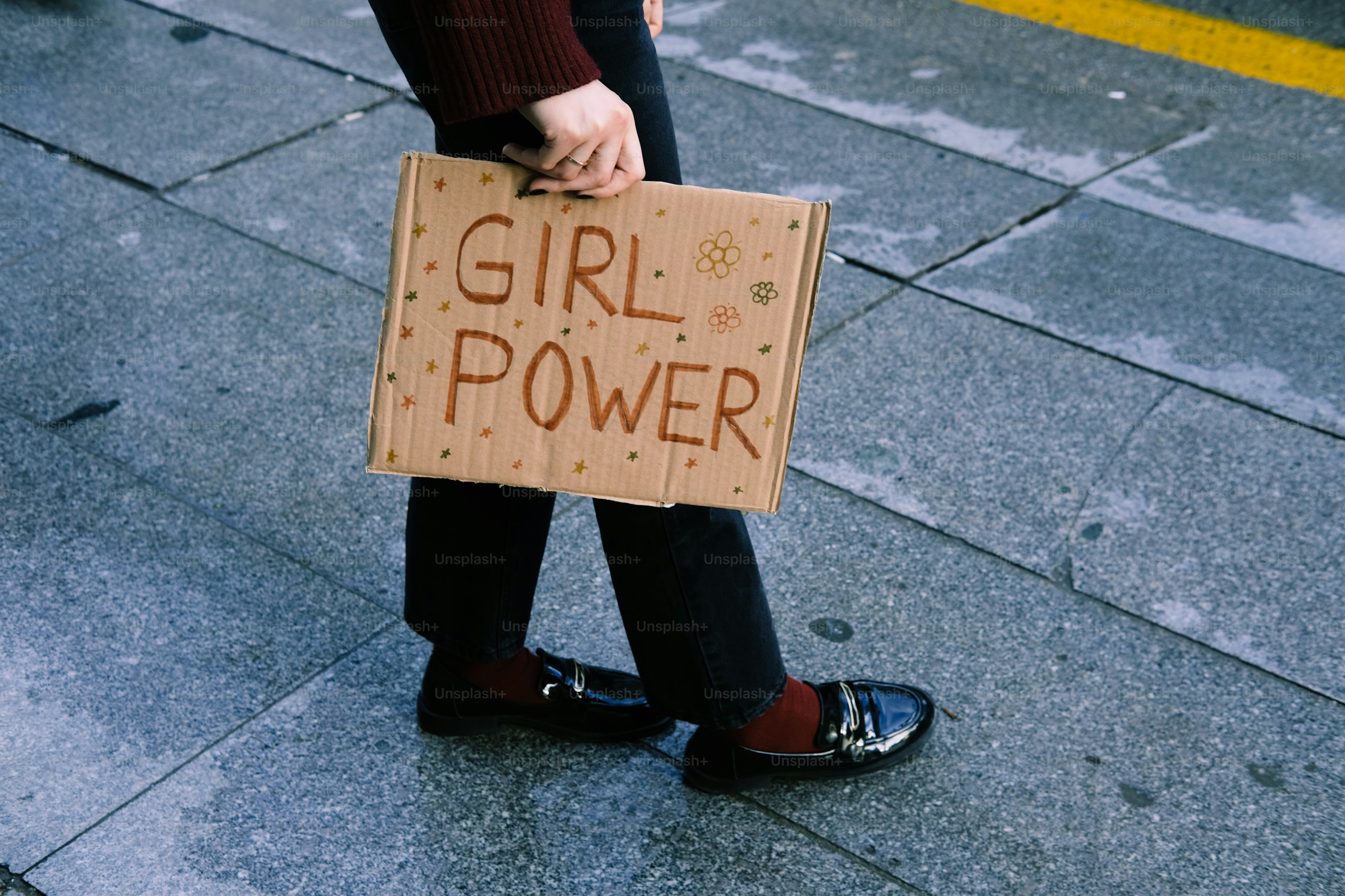 Une personne tenant un panneau indiquant le pouvoir des filles.