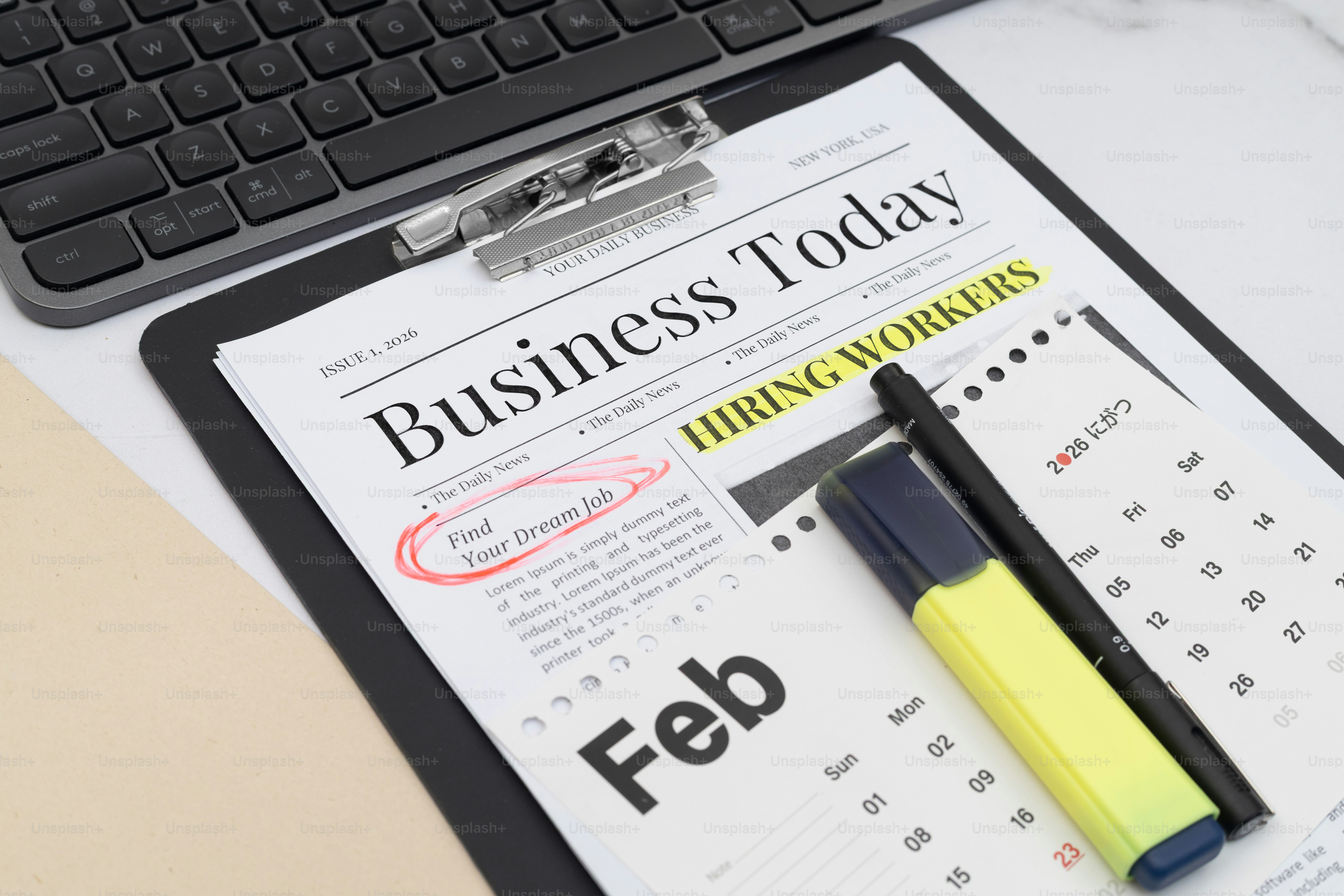 Clipboard dengan koran dan kalender 'bisnis hari ini'.