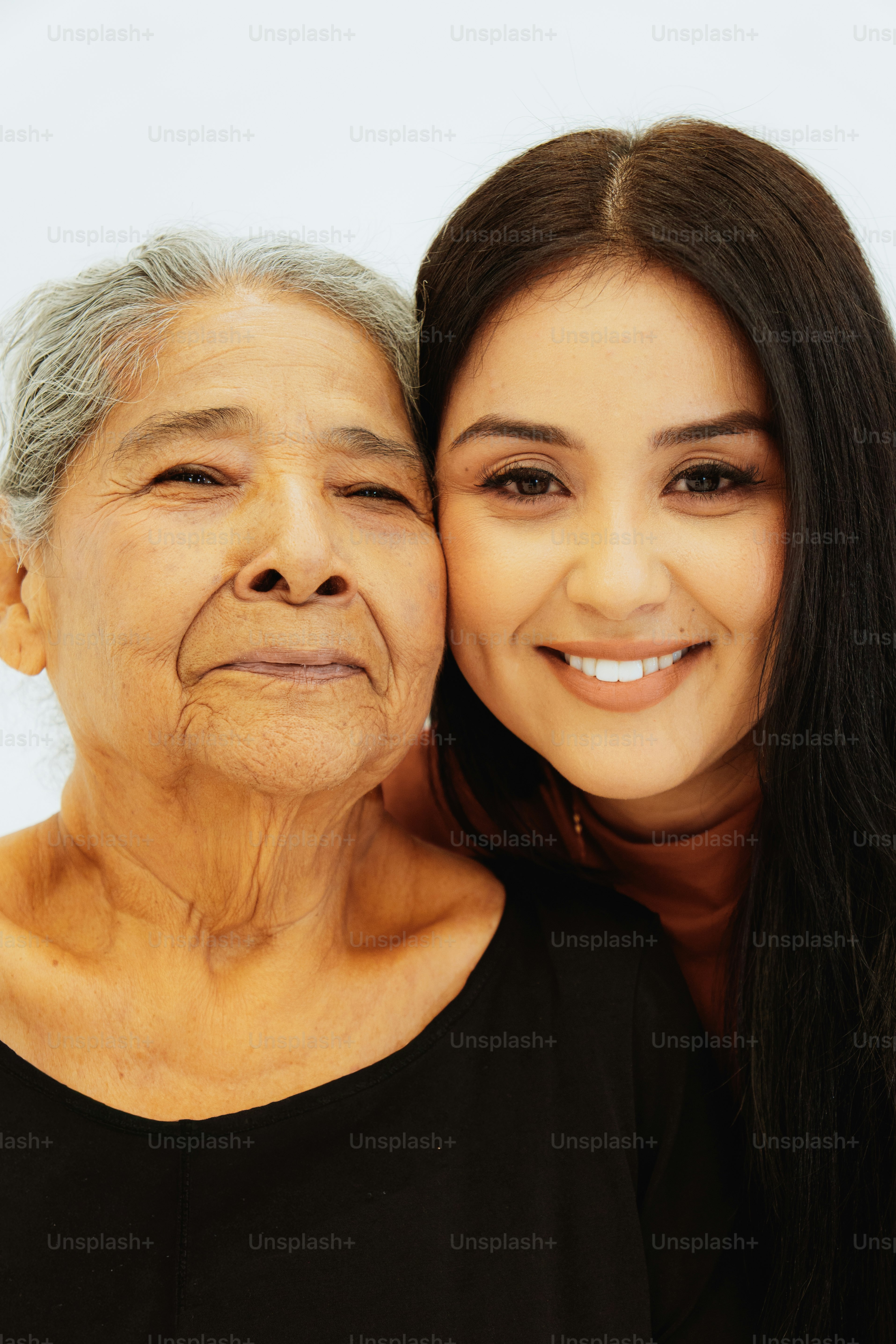 Hispanic grandmother and granddaughter smiling together