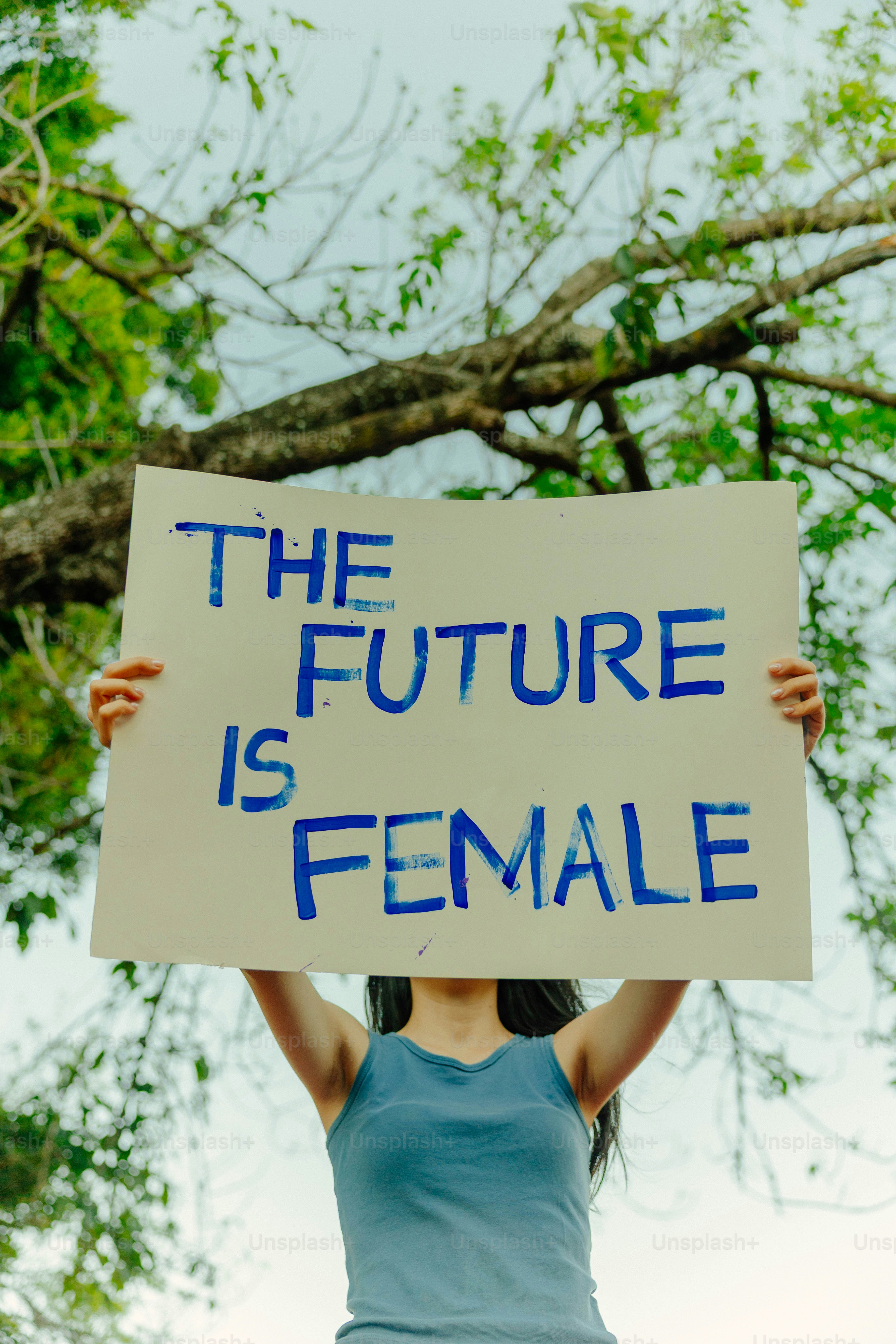 사람이 미래가 여성이라는 팻말을 들고 있습니다.