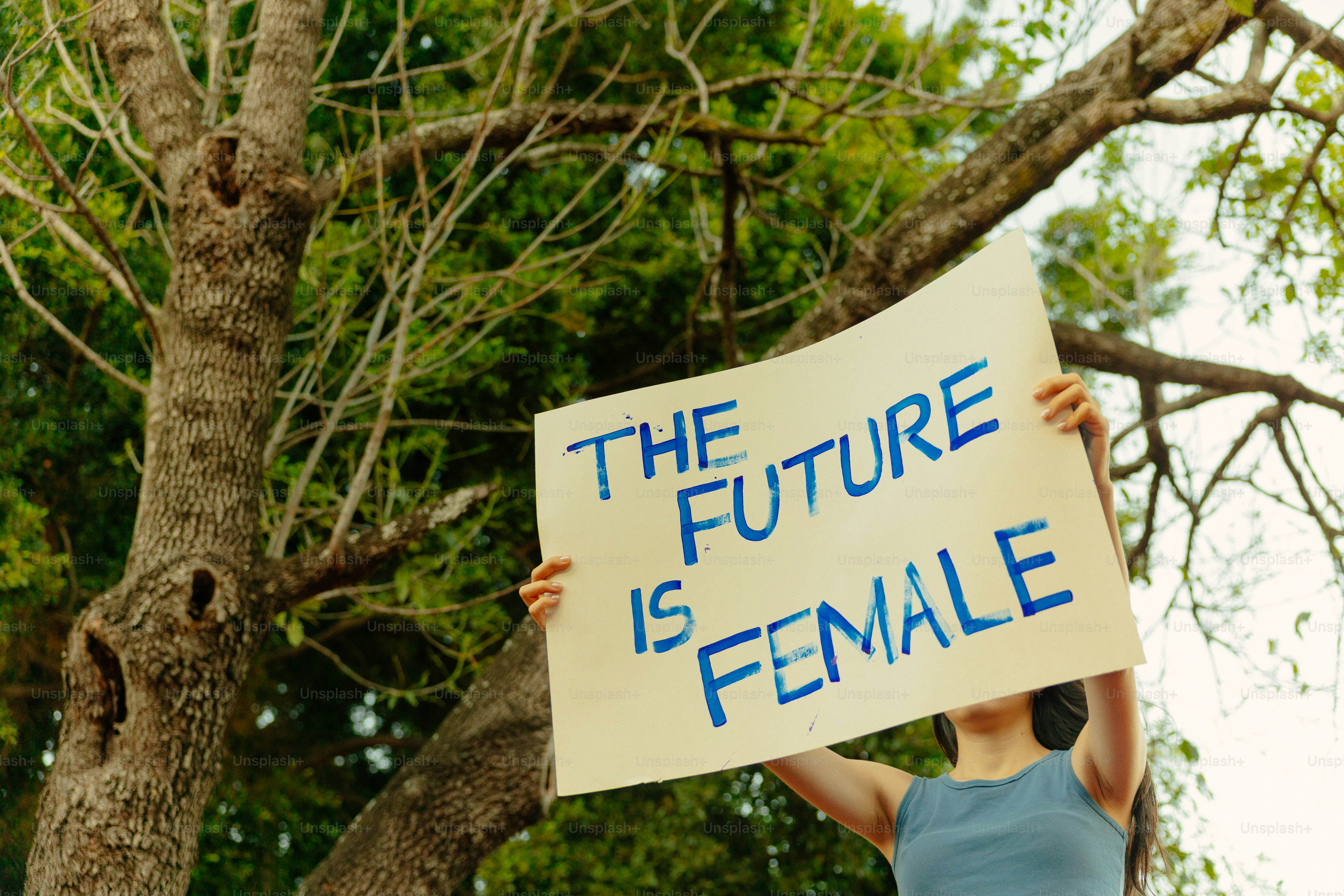 Person, die ein Schild hält, auf dem steht: 'Die Zukunft ist weiblich'.