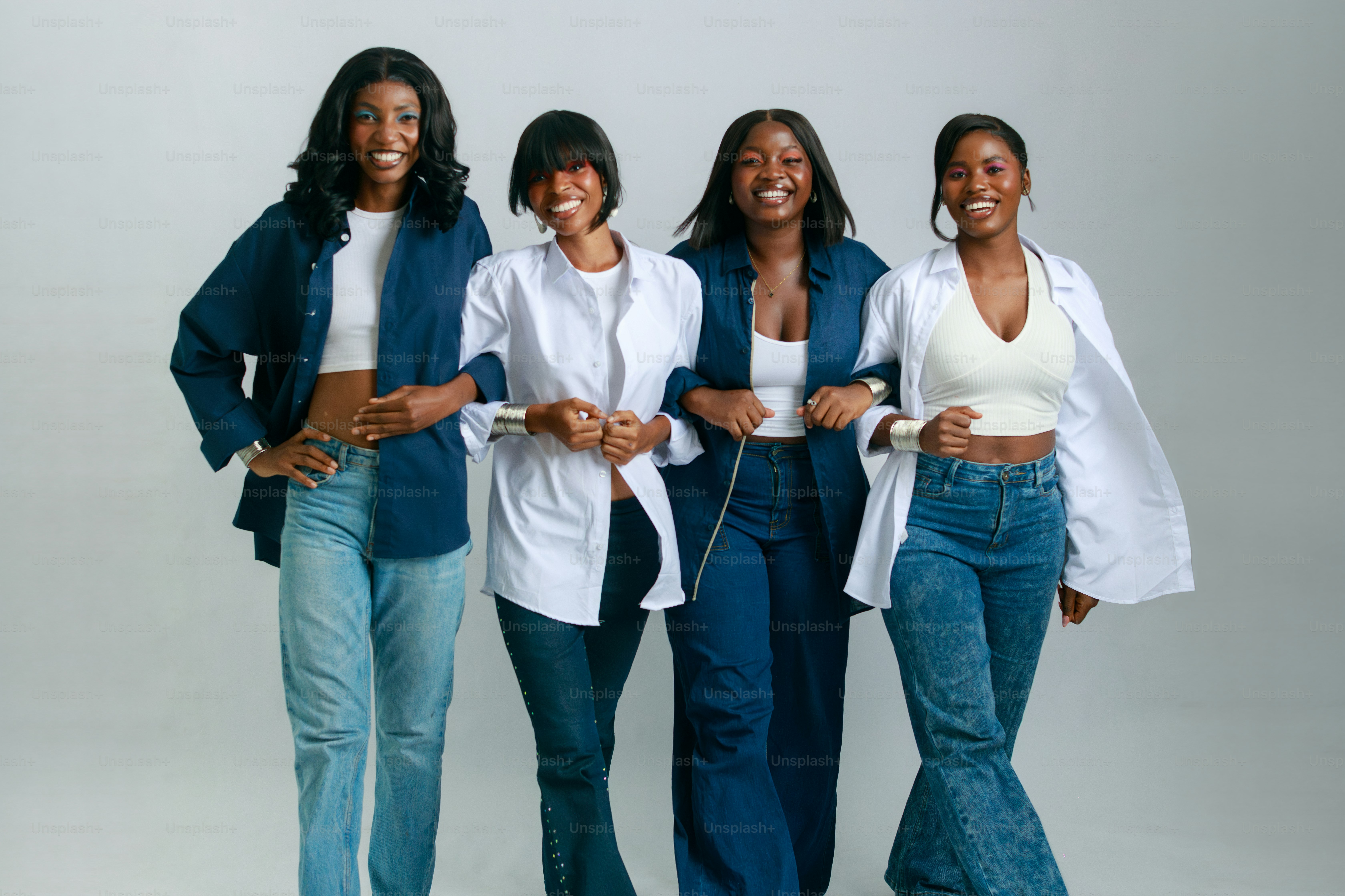 Four stylish black women arm in arm