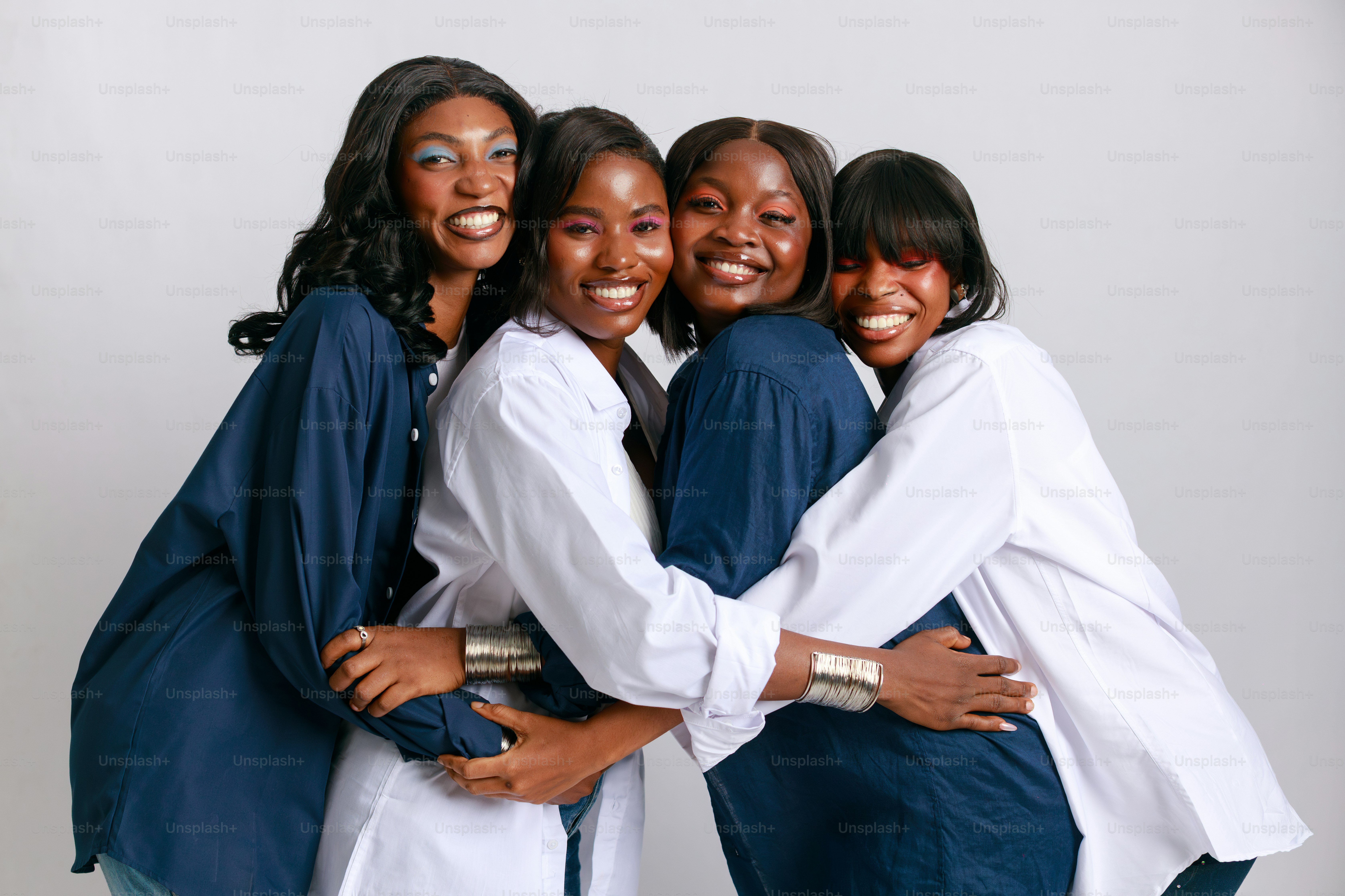 Four smiling women hug each other tightly