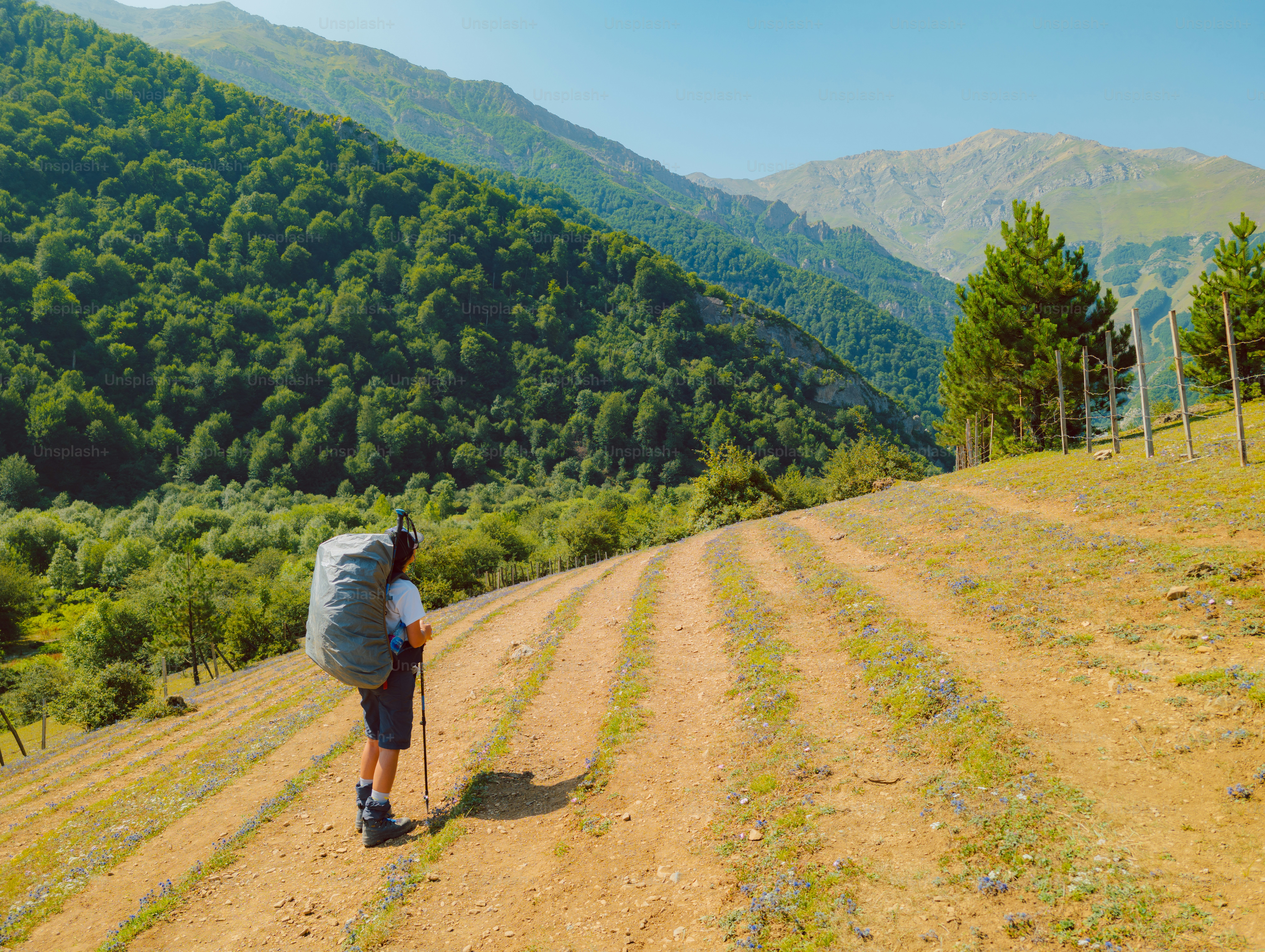 Hiker with large backpack on dirt path