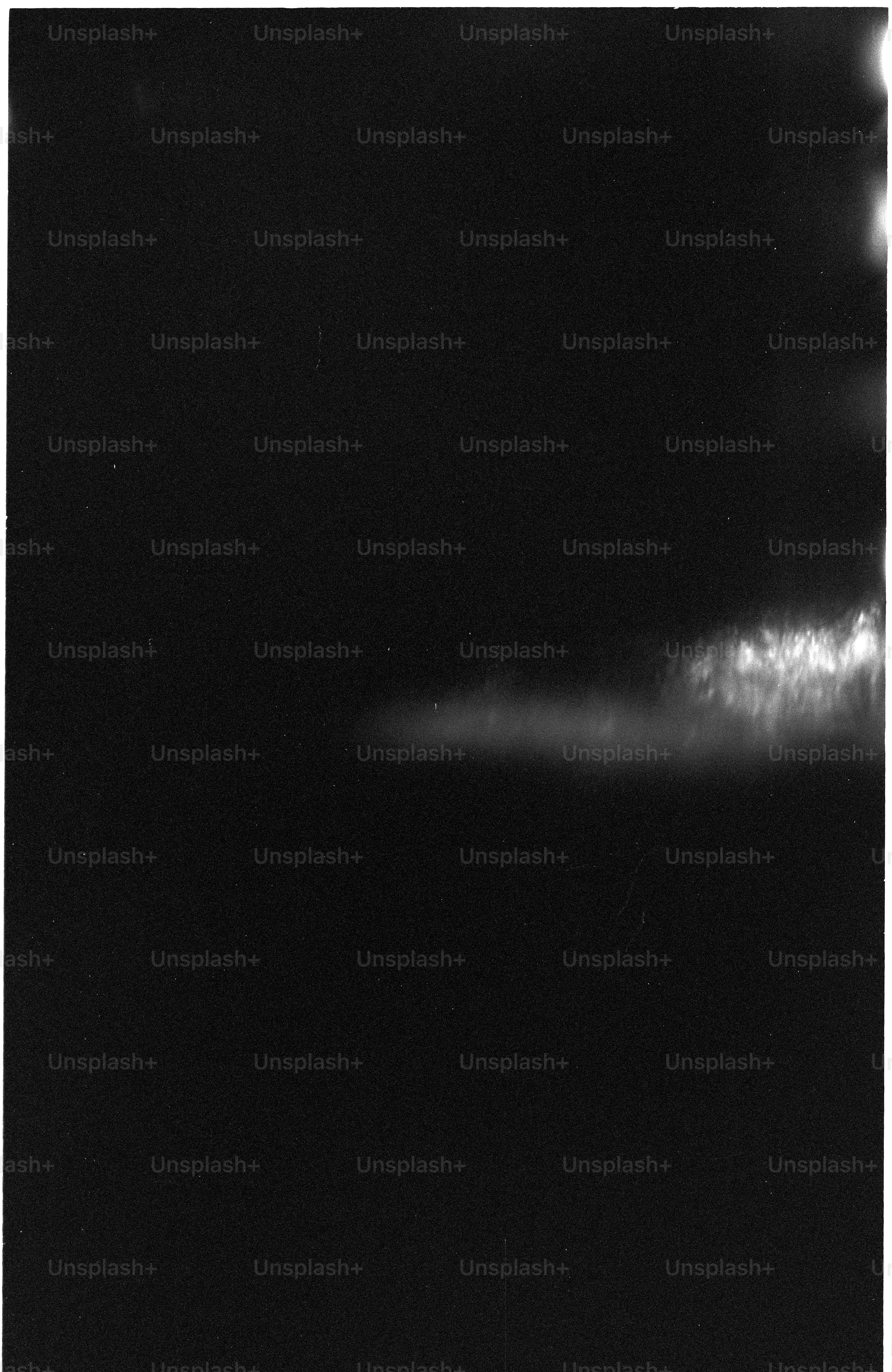 Dark sky with faint stars and a bright cloud formation.