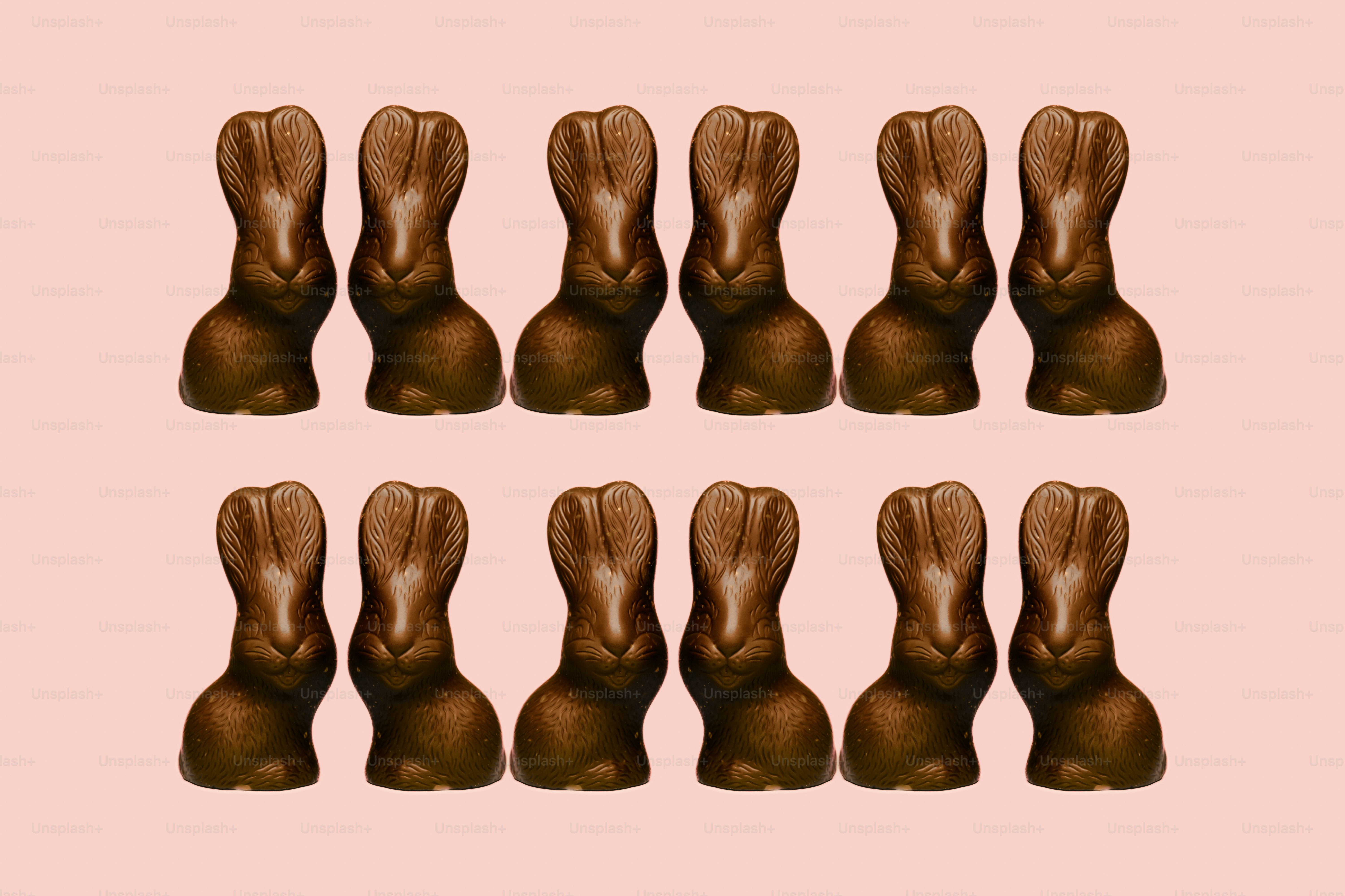 Rows of chocolate bunny candies on pink background
