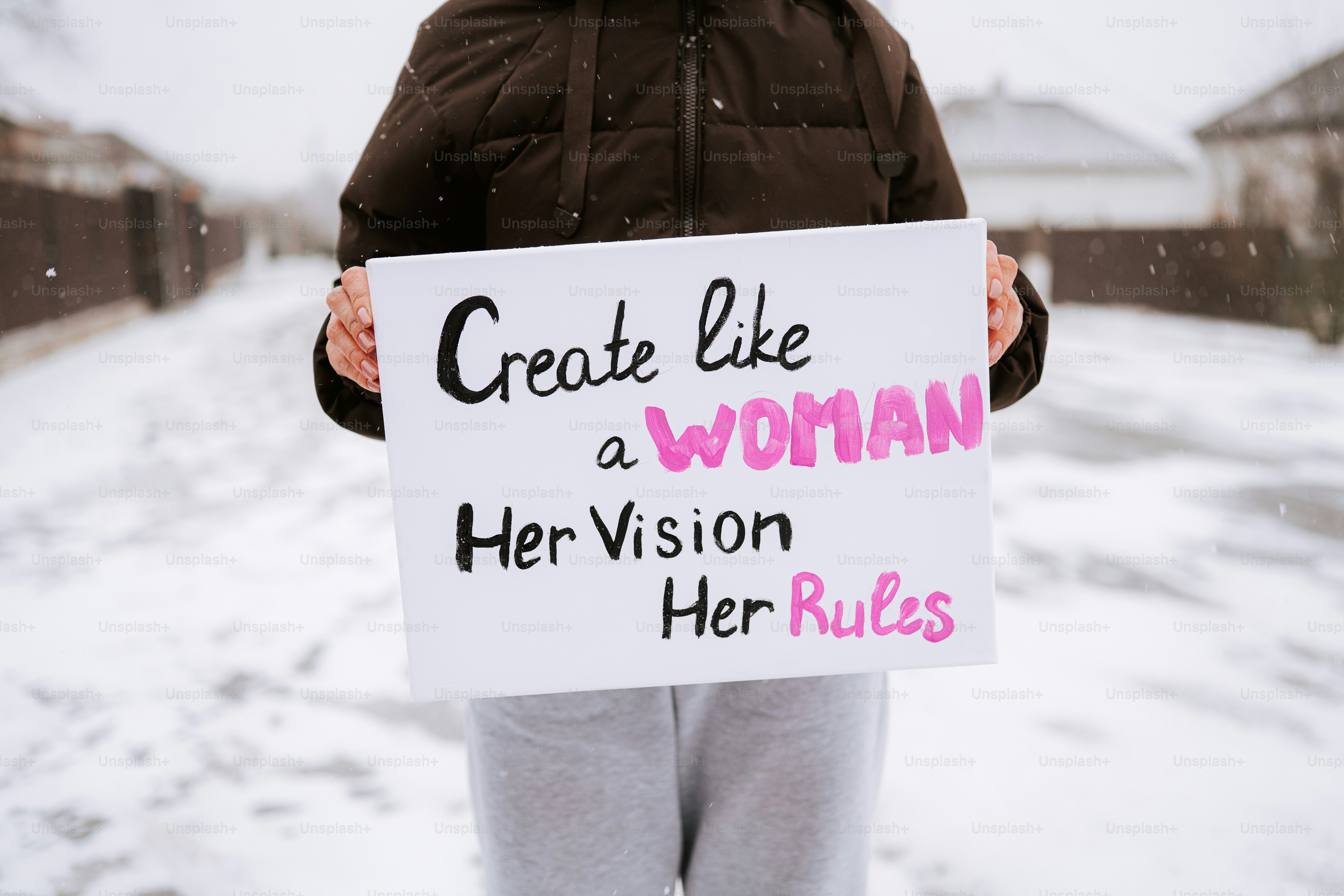 Person holds sign with feminist slogan in winter