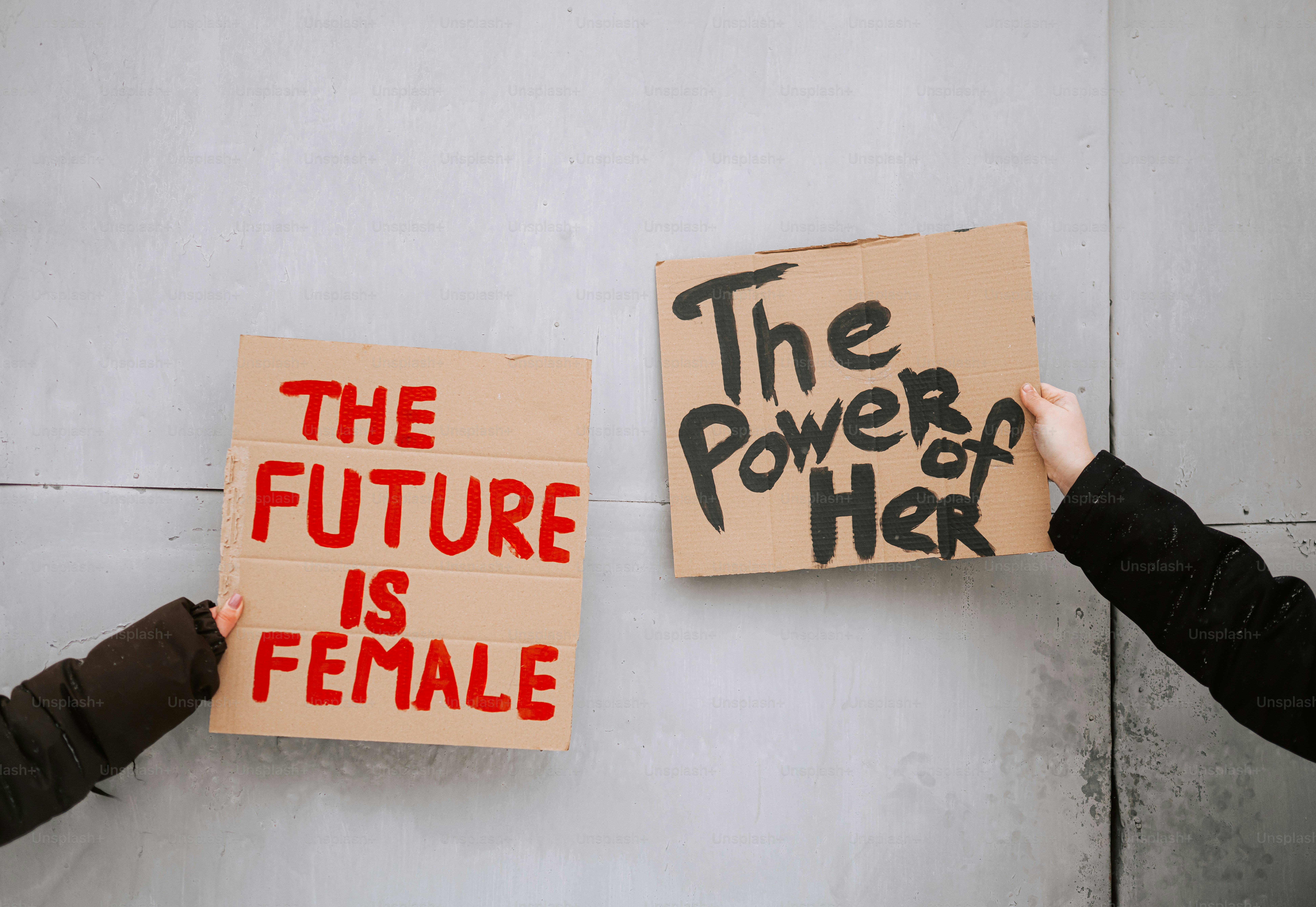 Two signs held up with feminist messages