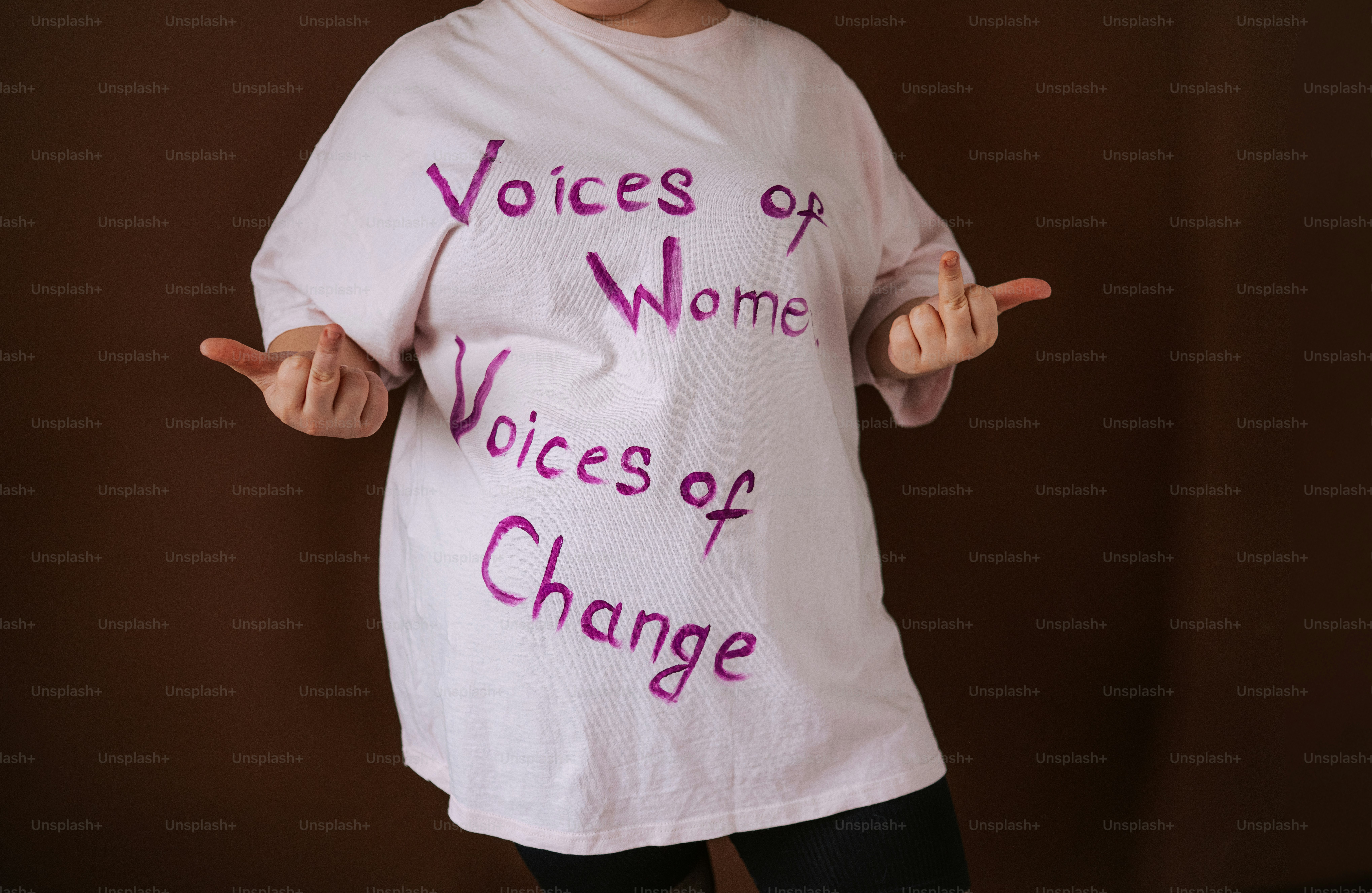 Une femme porte un t-shirt avec « voix de femmes, voix de changement ».