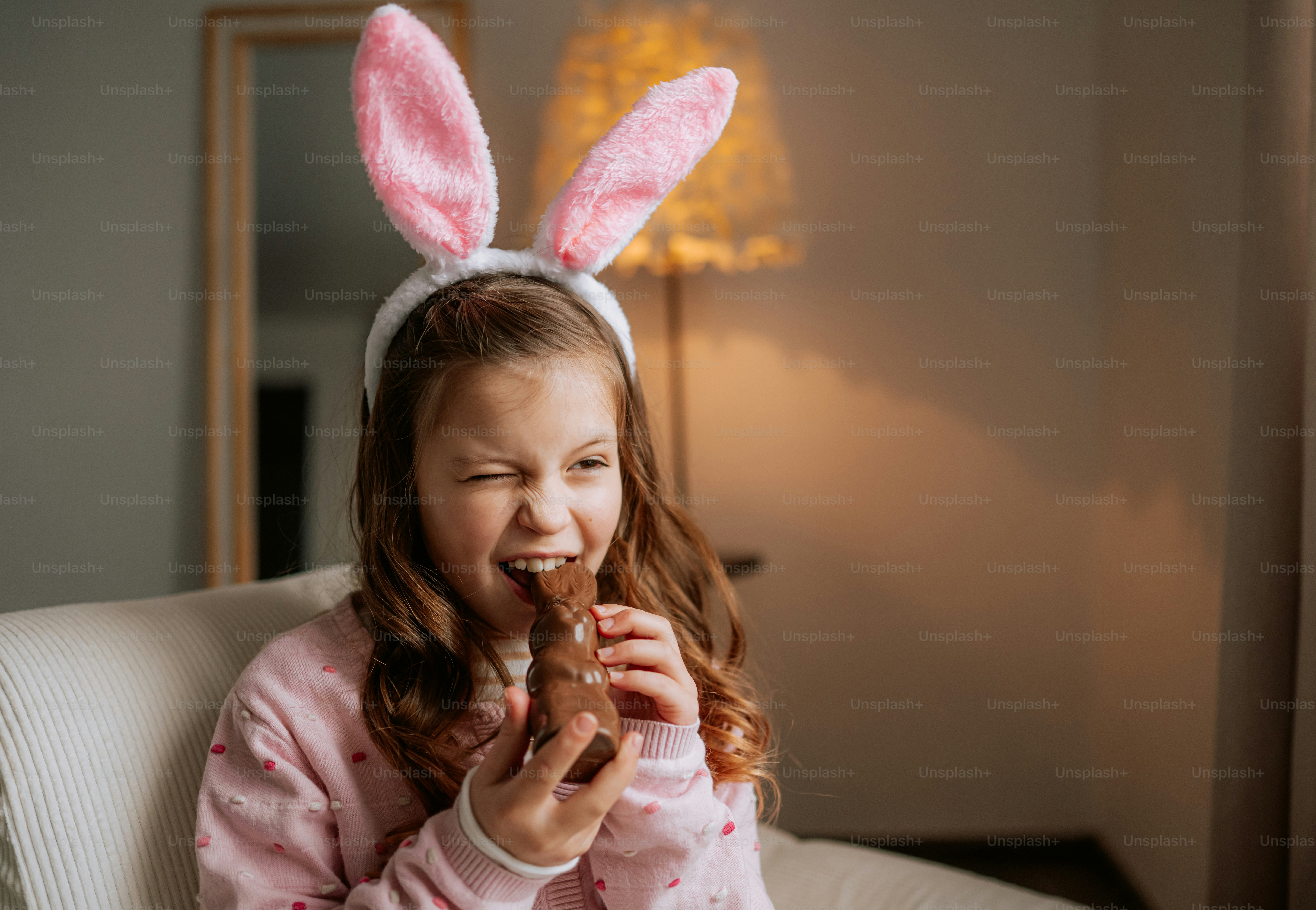Girl with bunny ears eats chocolate bunny