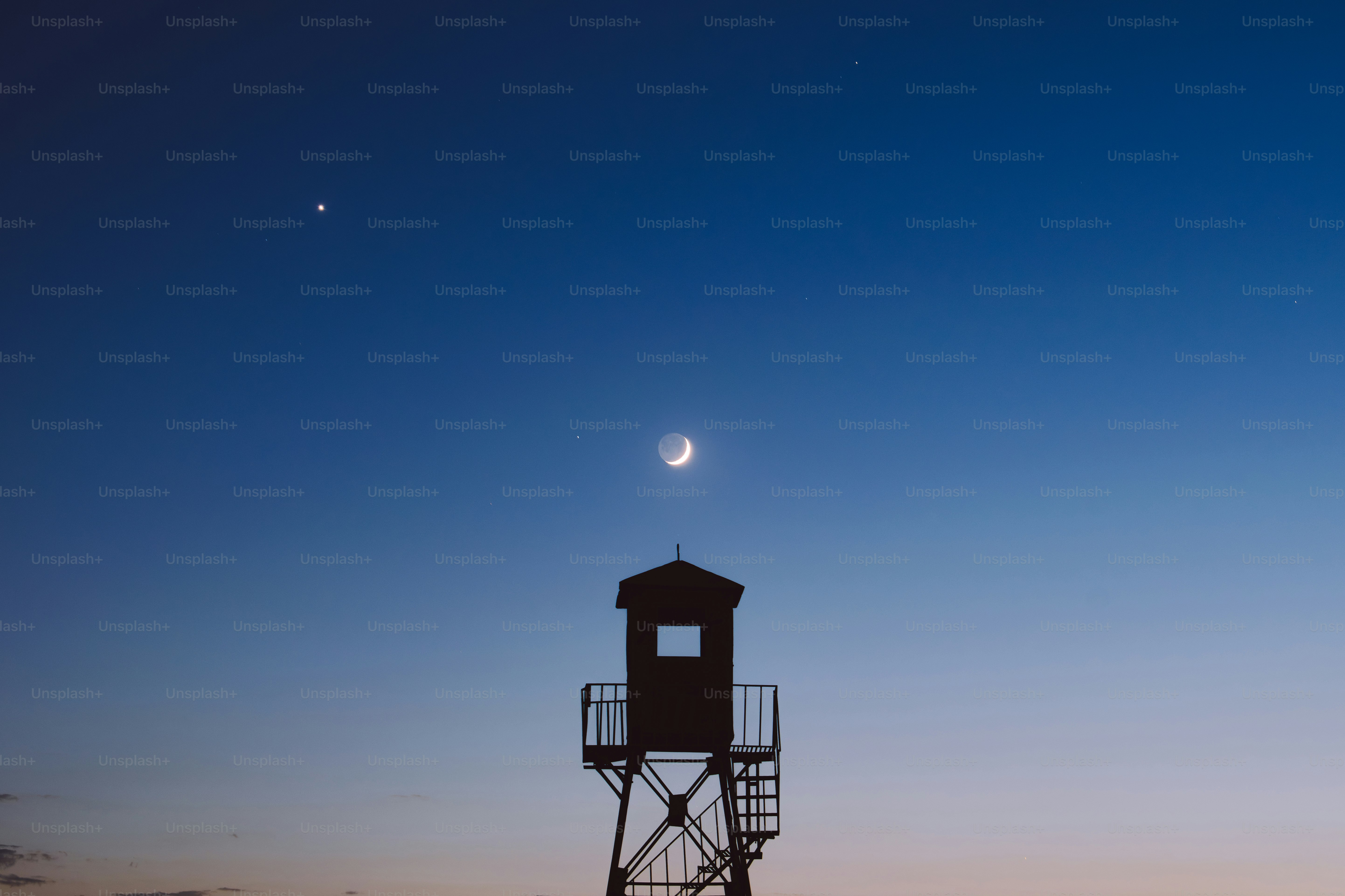 Crescent moon and stars above a watchtower.
