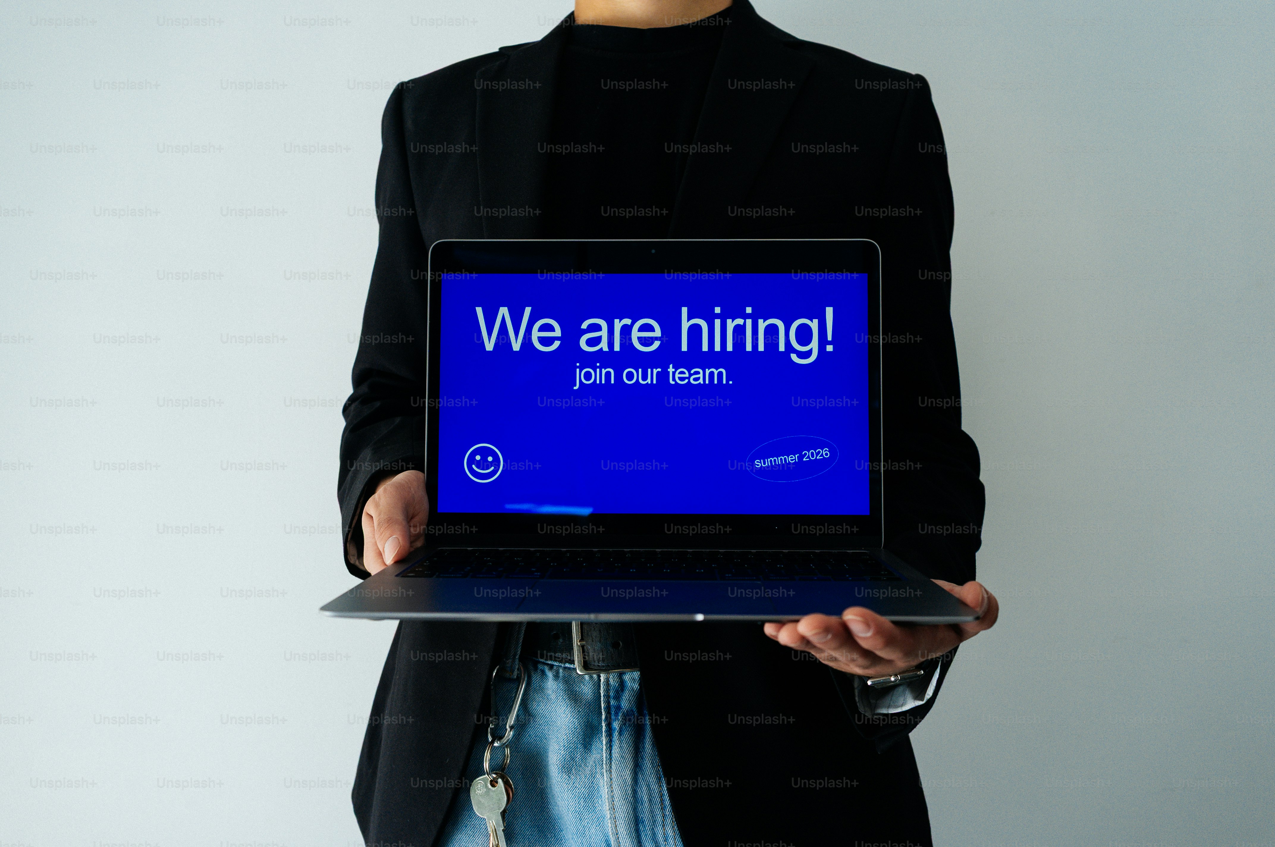 Une personne tient un ordinateur portable affichant le message « nous recrutons ! ».