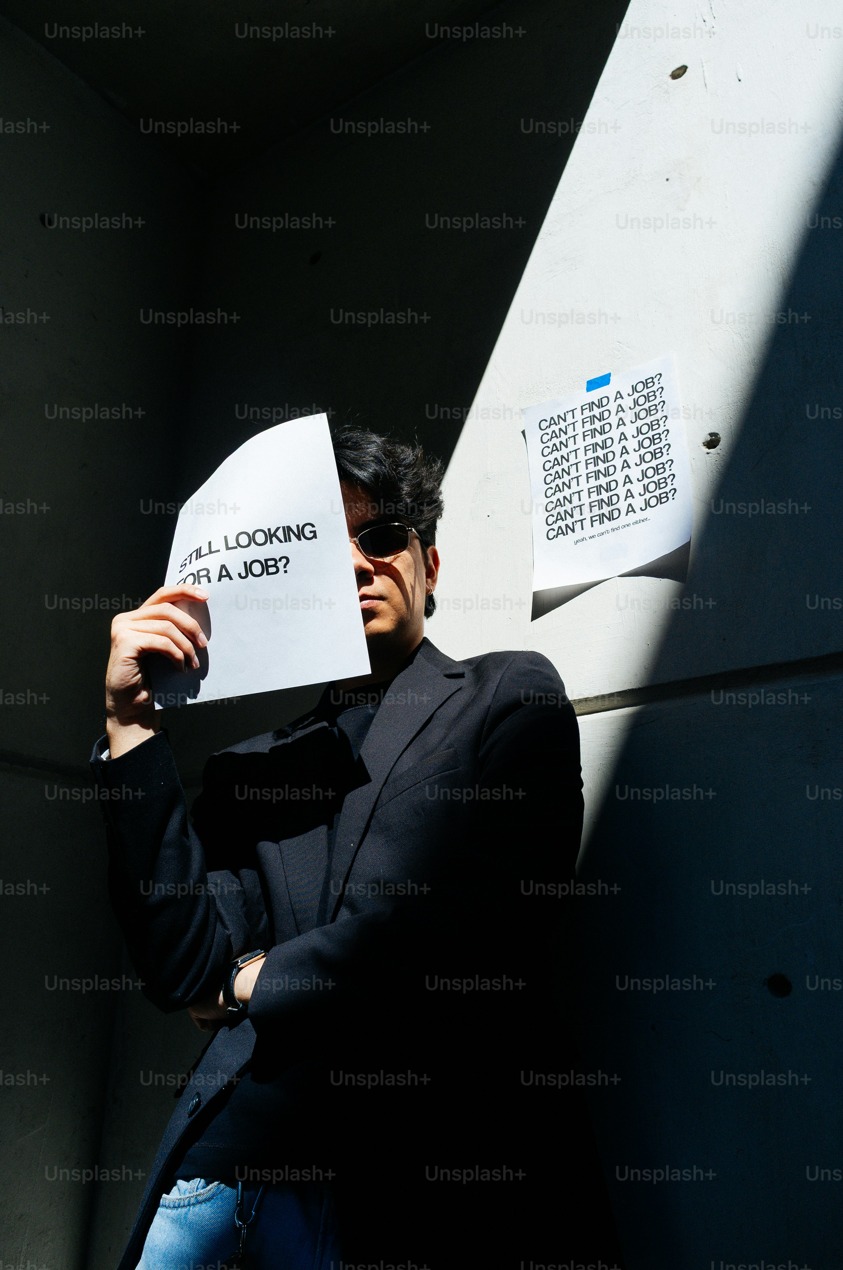 Un homme tenant un papier demandant « toujours à chercher un emploi ? »