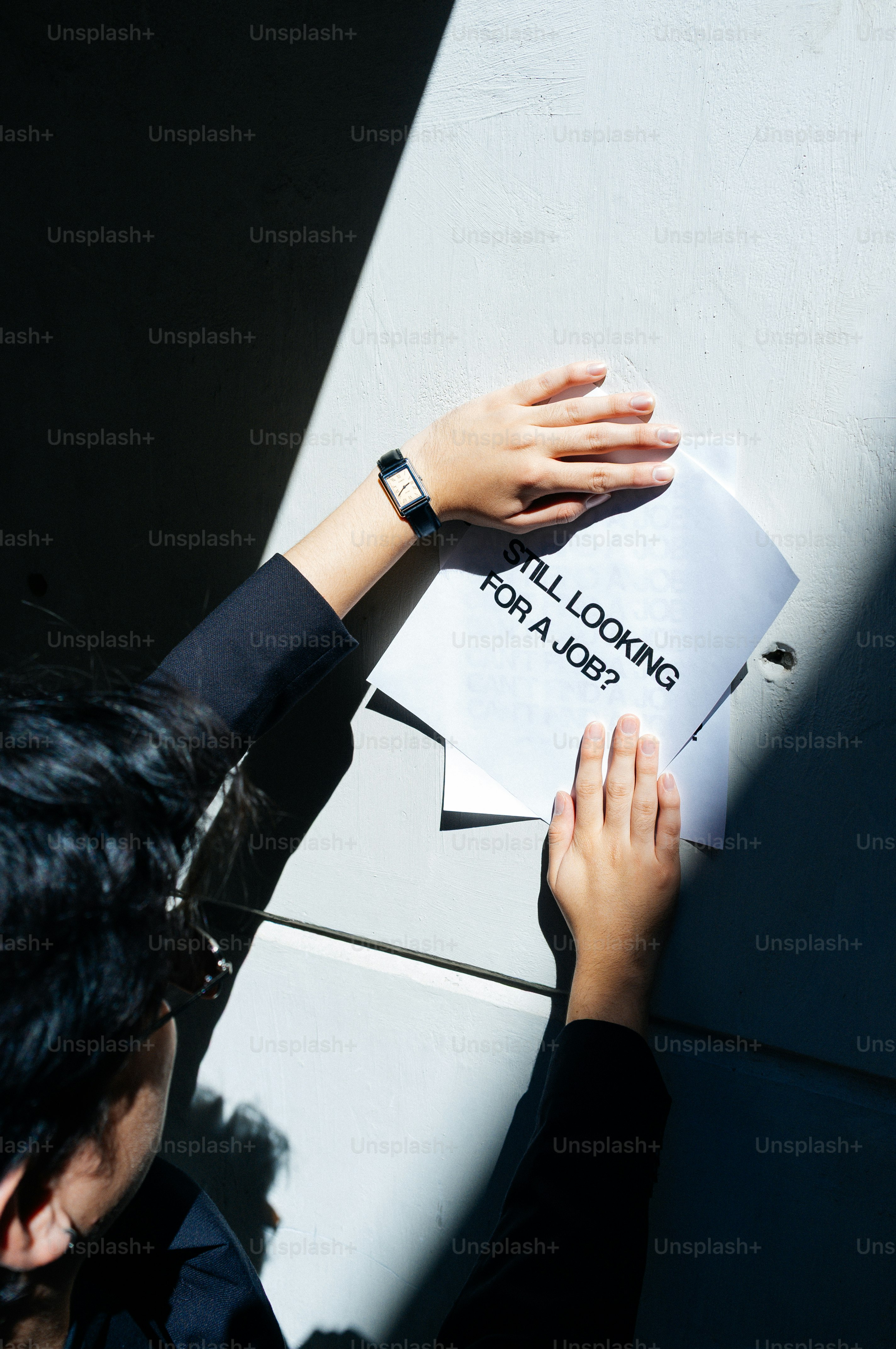 Une personne tenant un papier qui dit « toujours à la recherche d’un emploi » ?