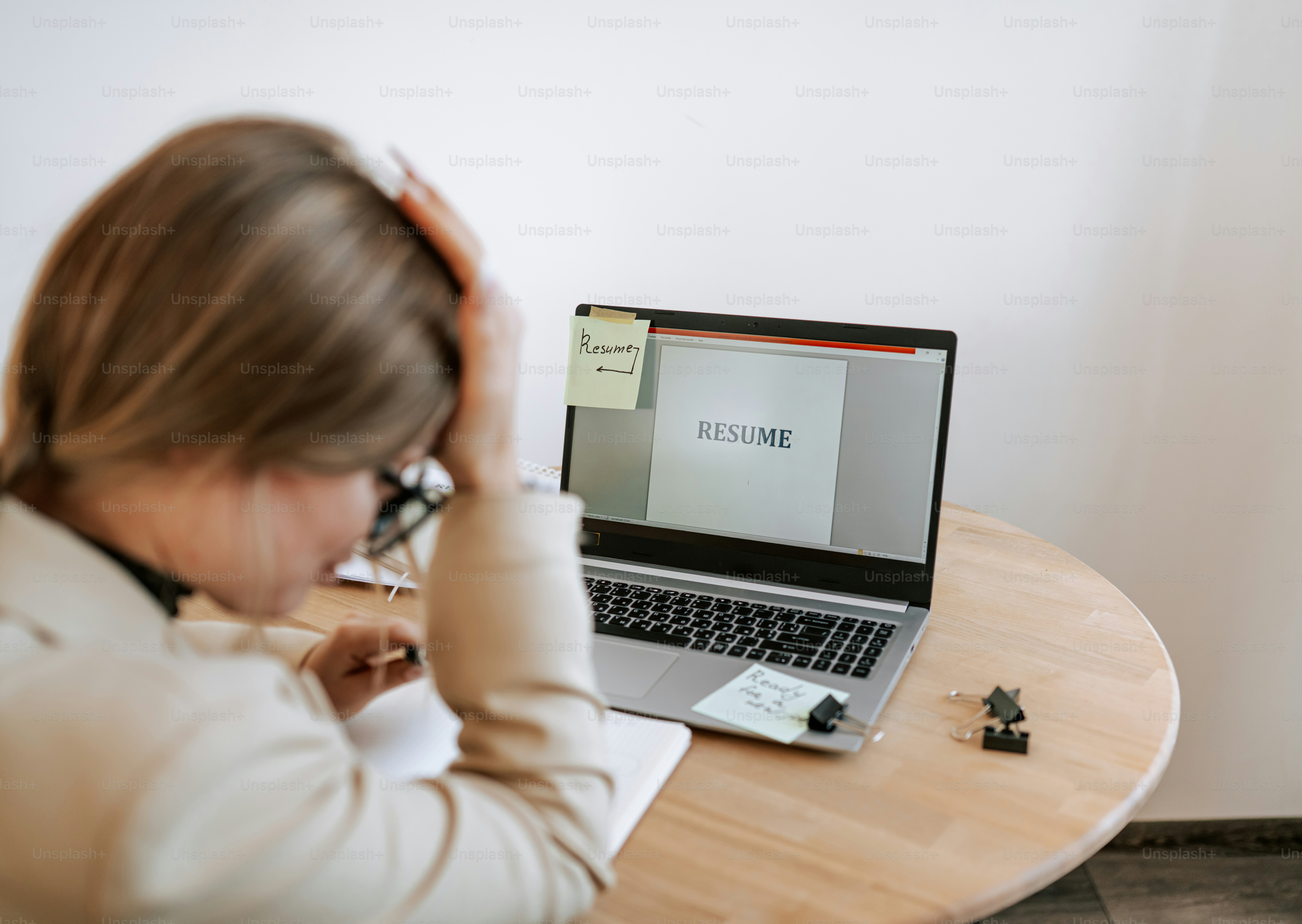 Woman stressed while looking at resume on laptop