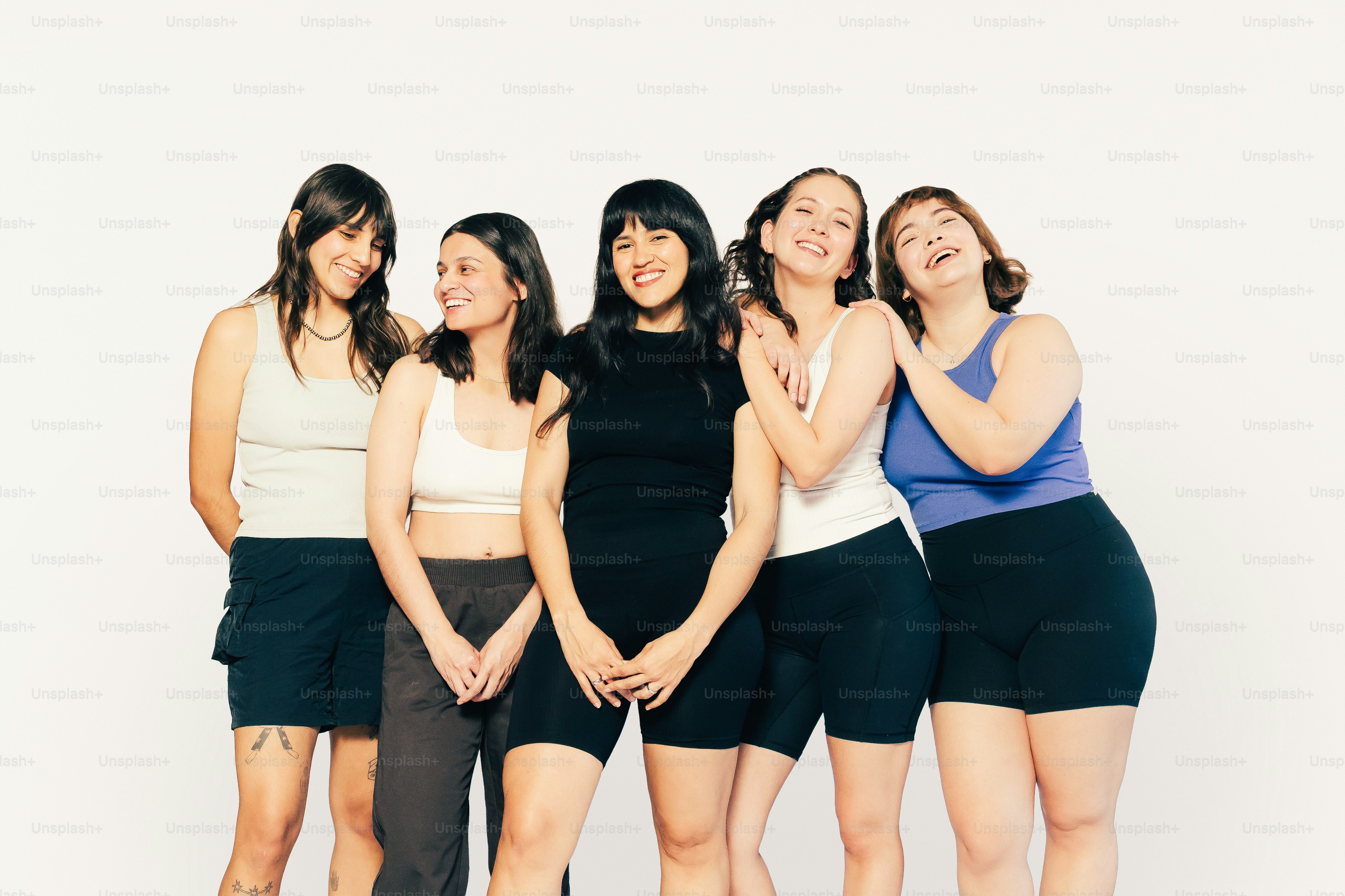 Cinco mujeres posando juntas con sonrisas