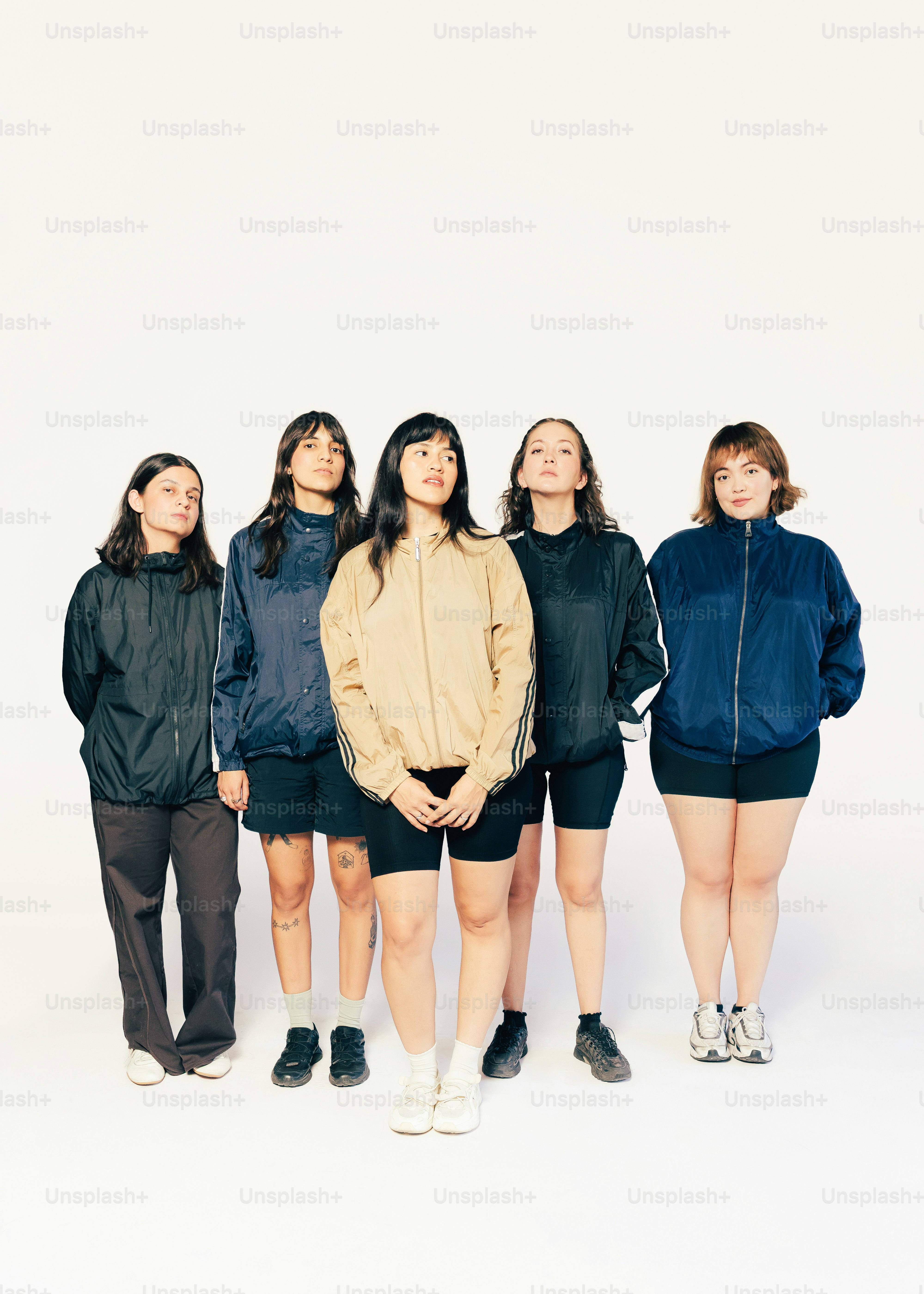 5人の女性が白い背景に一列に立っています。