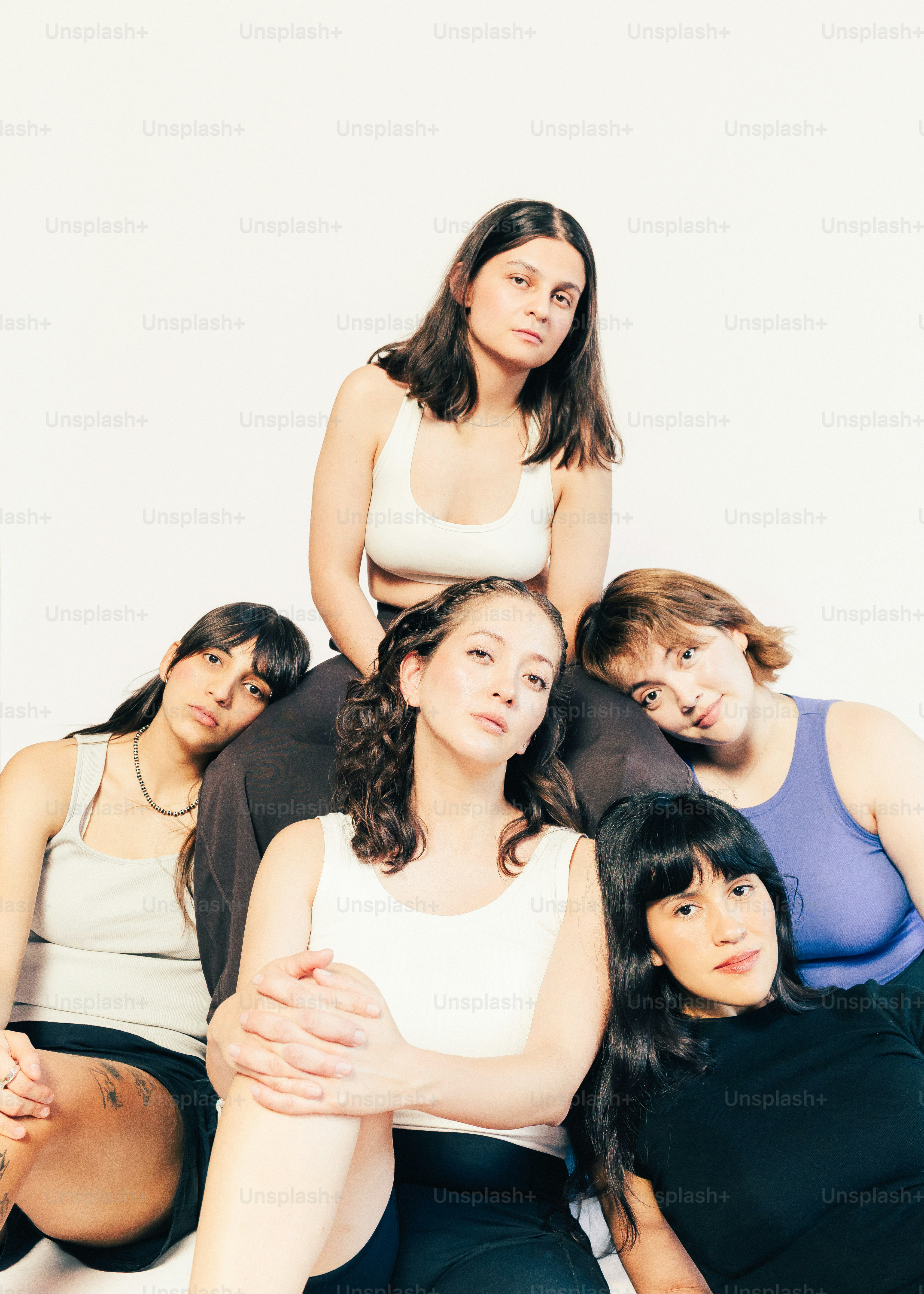 Five women posing together against a white background.