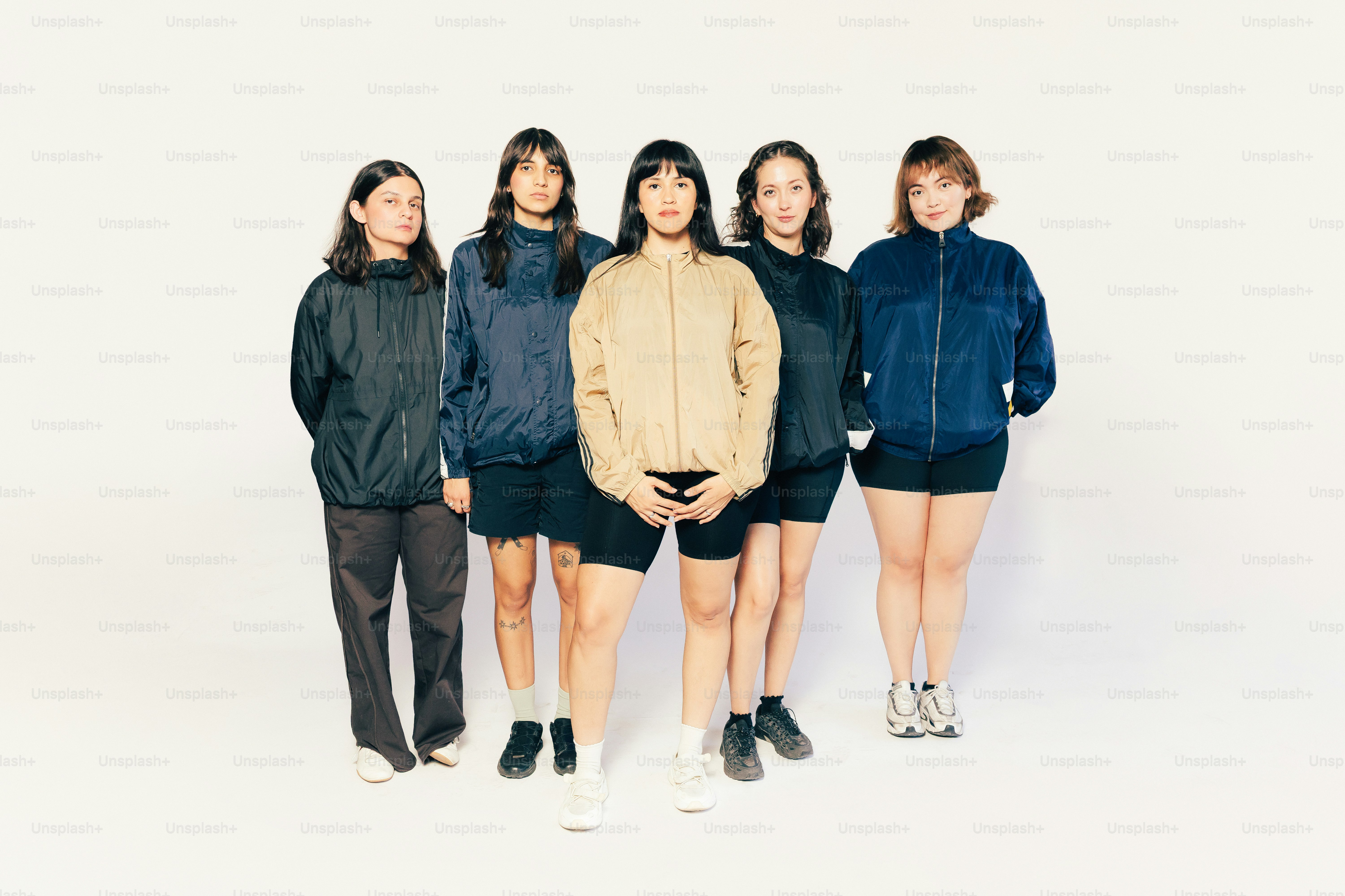 白い背景に、運動着姿の5人の女性が立っています。