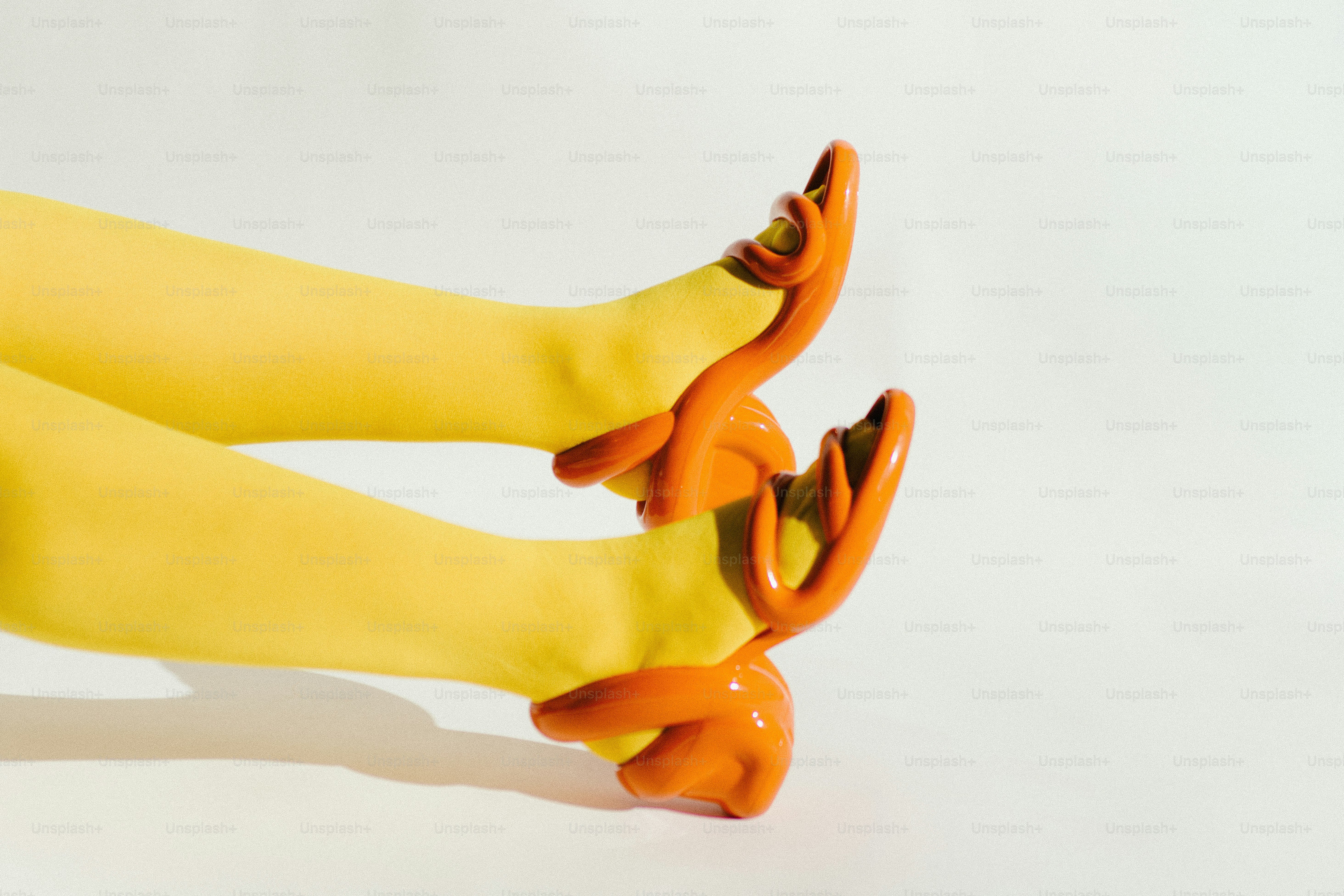 Yellow gloves with orange tips on white background
