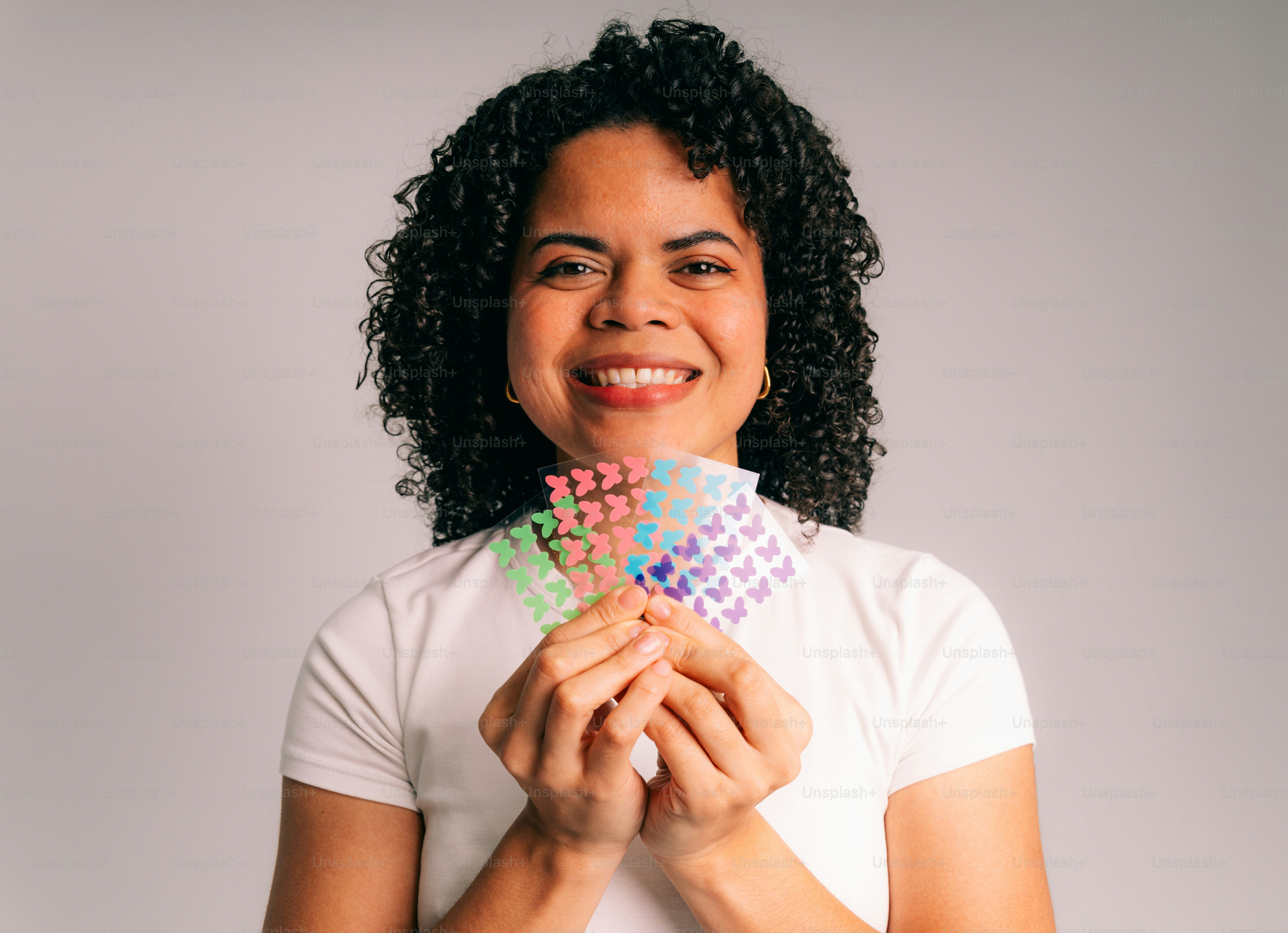 カラフルな蝶のシールを持つ女性