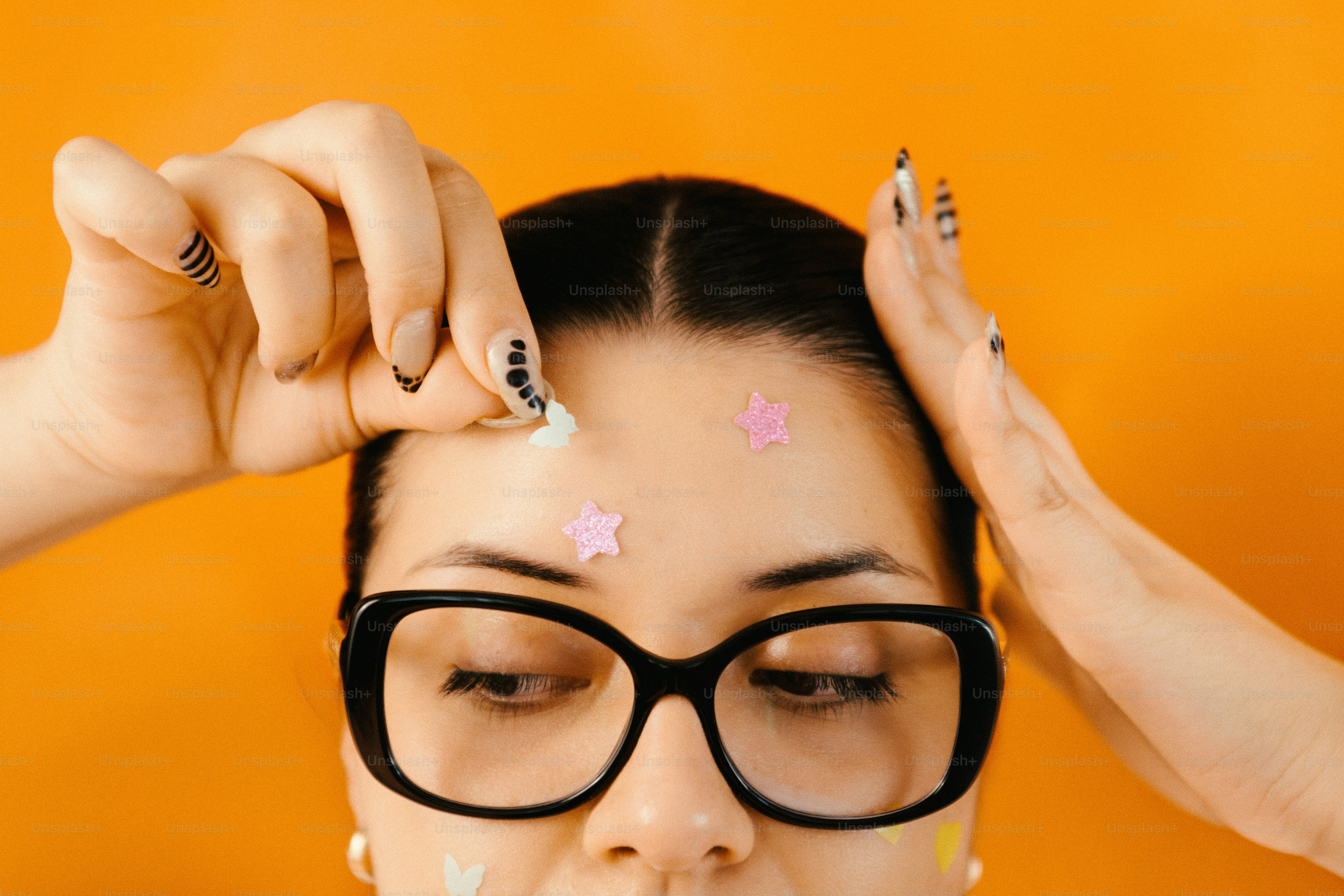 額に星のシールを貼る女性