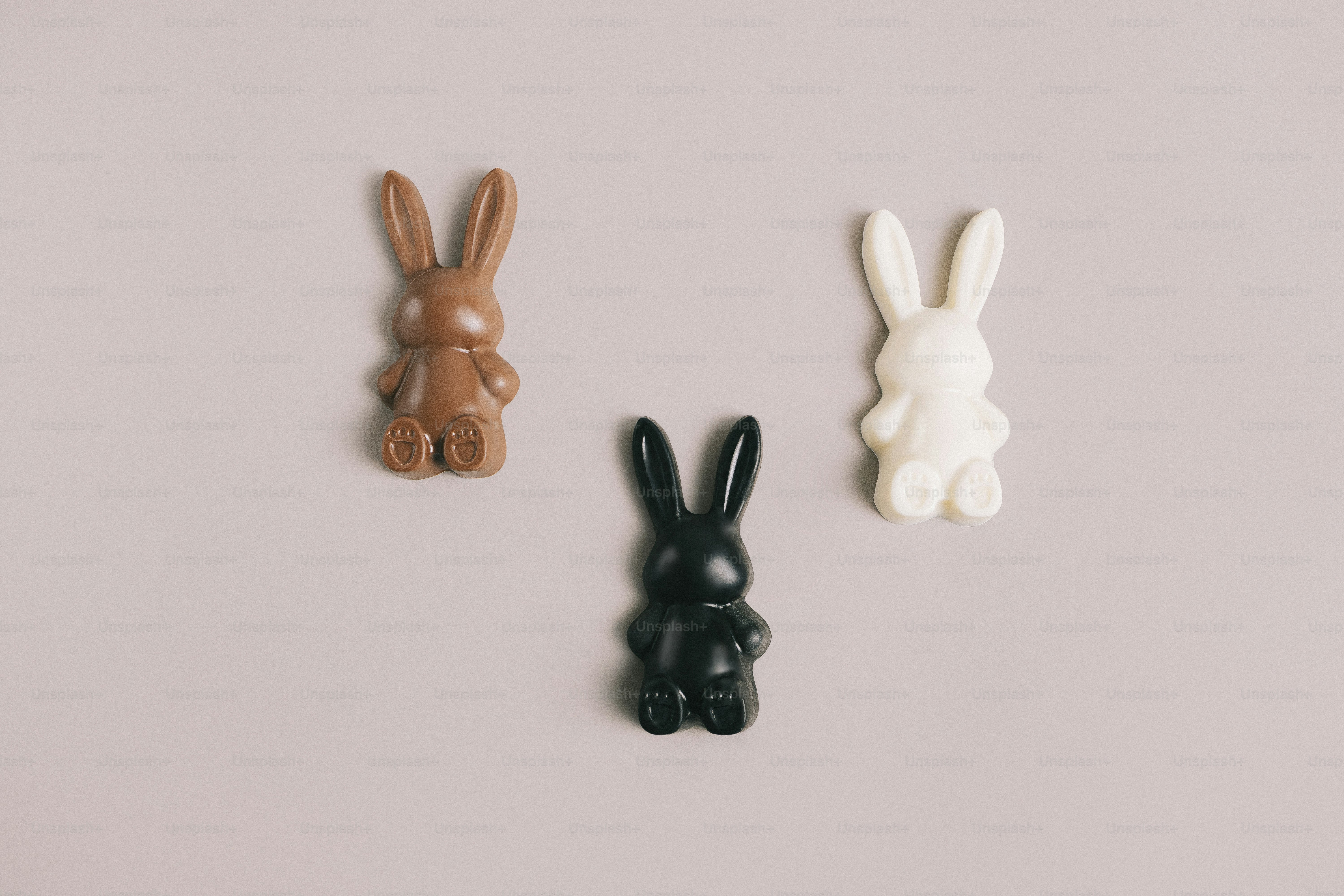 Three chocolate bunnies on a plain background