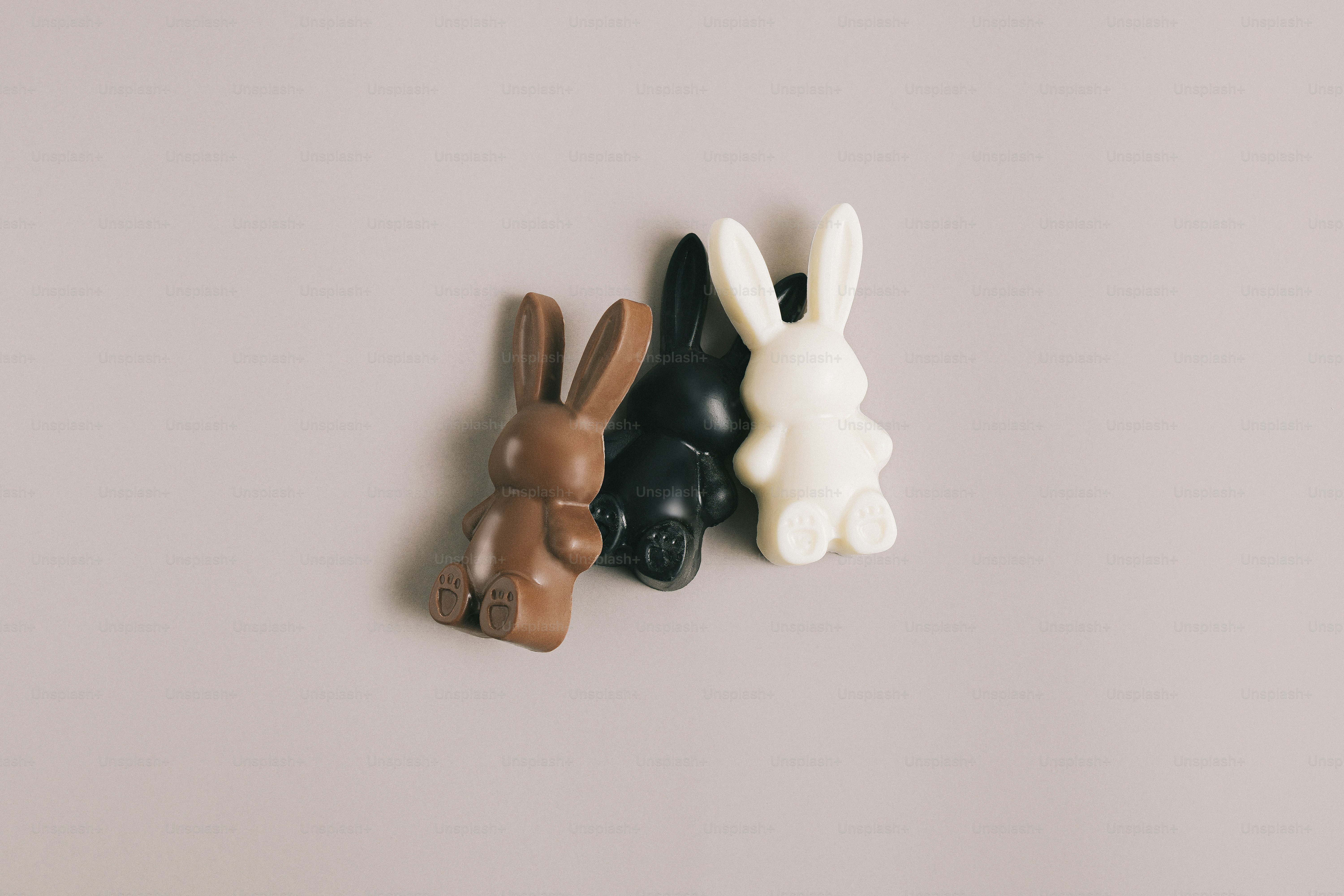 Three chocolate bunnies on a plain background