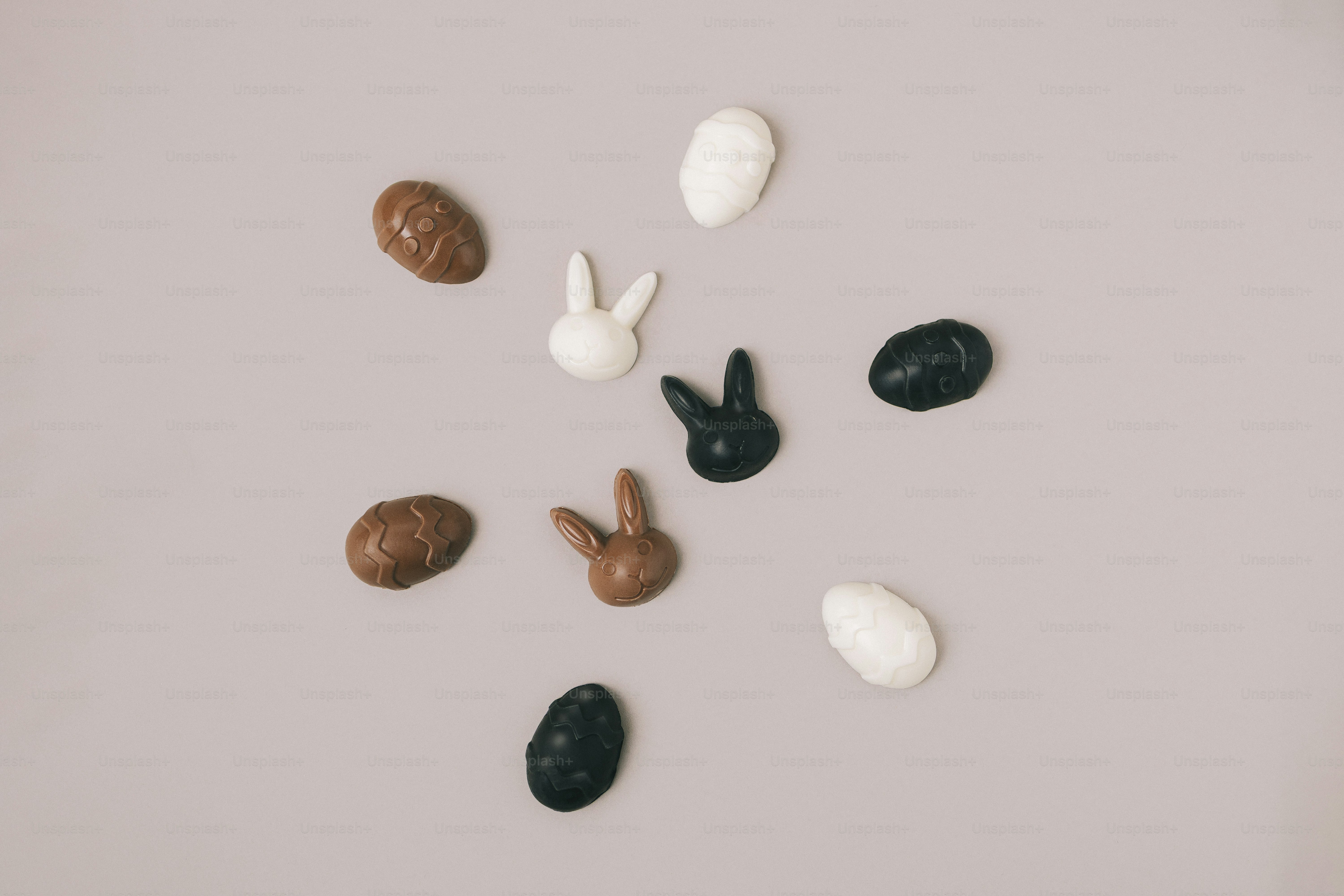 Easter chocolates and bunny heads arranged on a gray background.