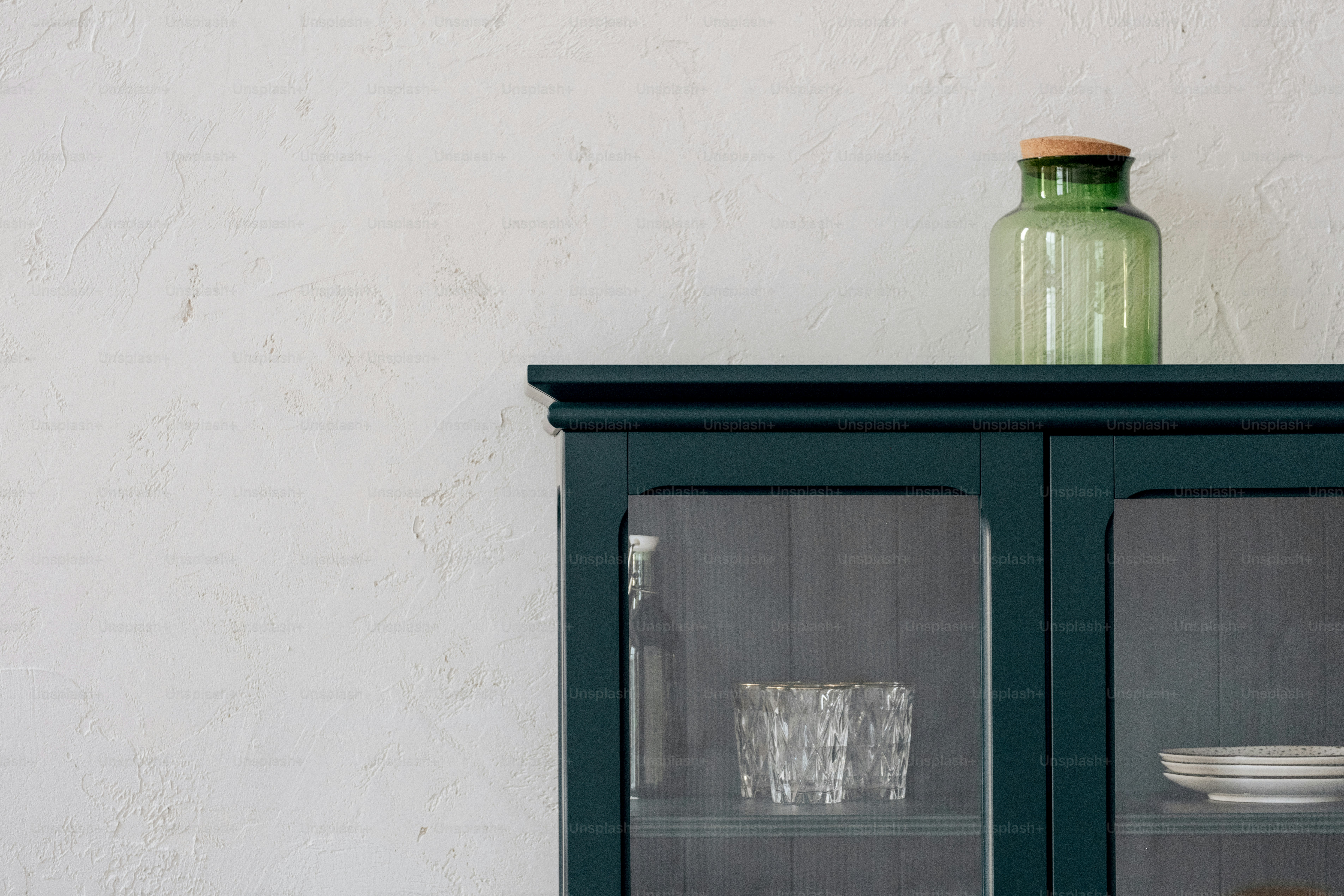 Green glass jar on top of a dark blue cabinet