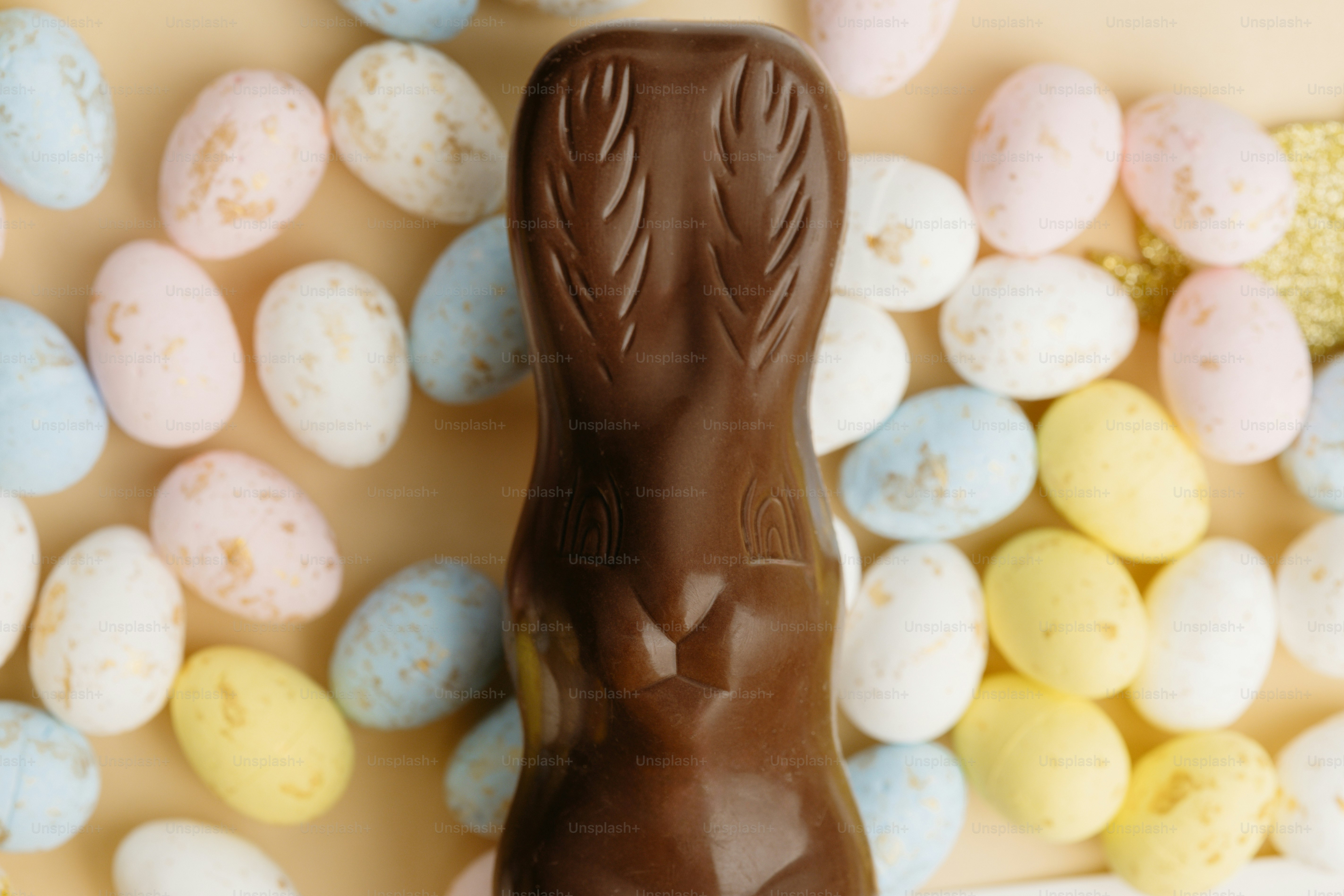 Conejita de chocolate rodeada de huevos de pascua en tonos pastel