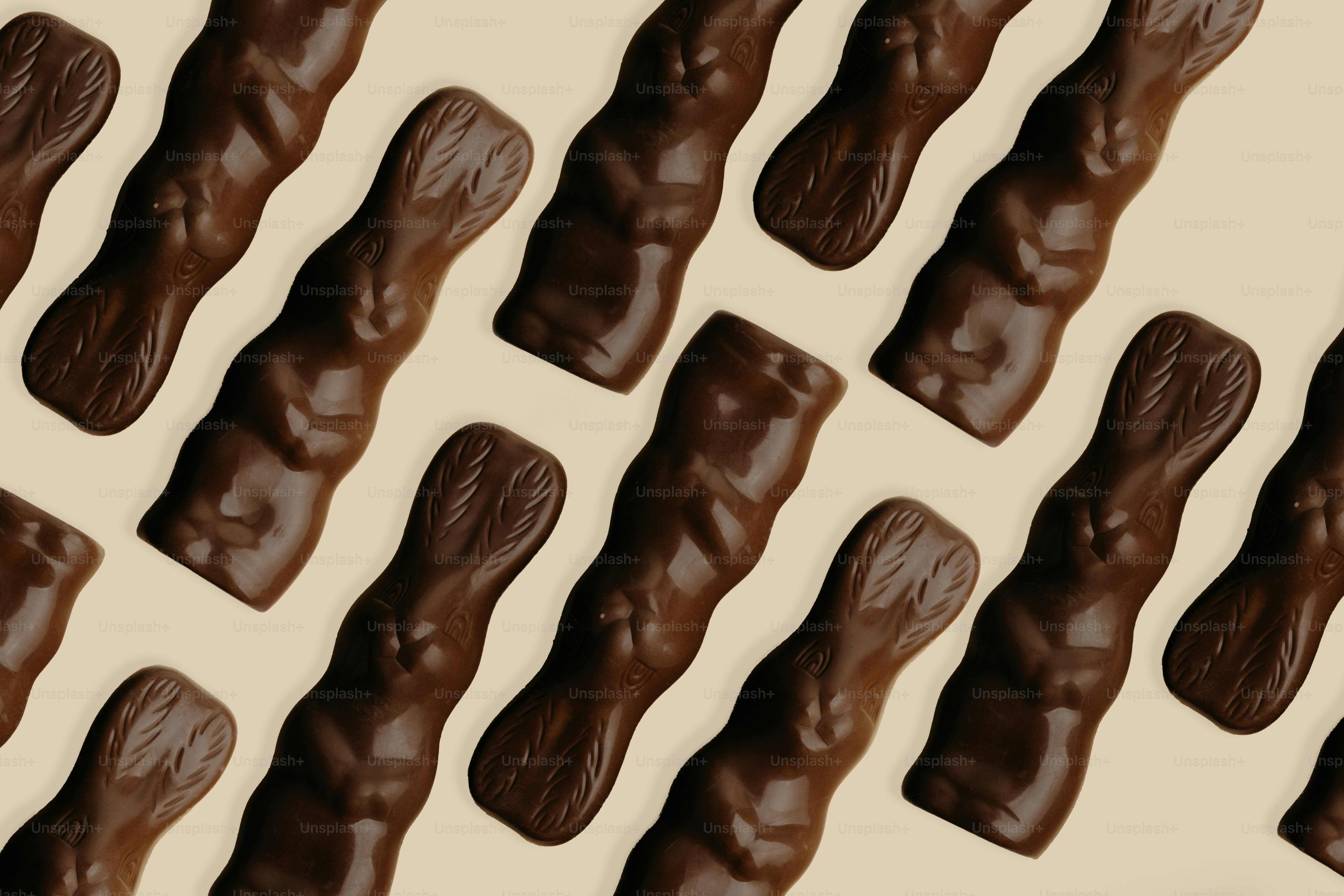 Caramelos de conejito de chocolate negro dispuestos en diagonal sobre un fondo claro