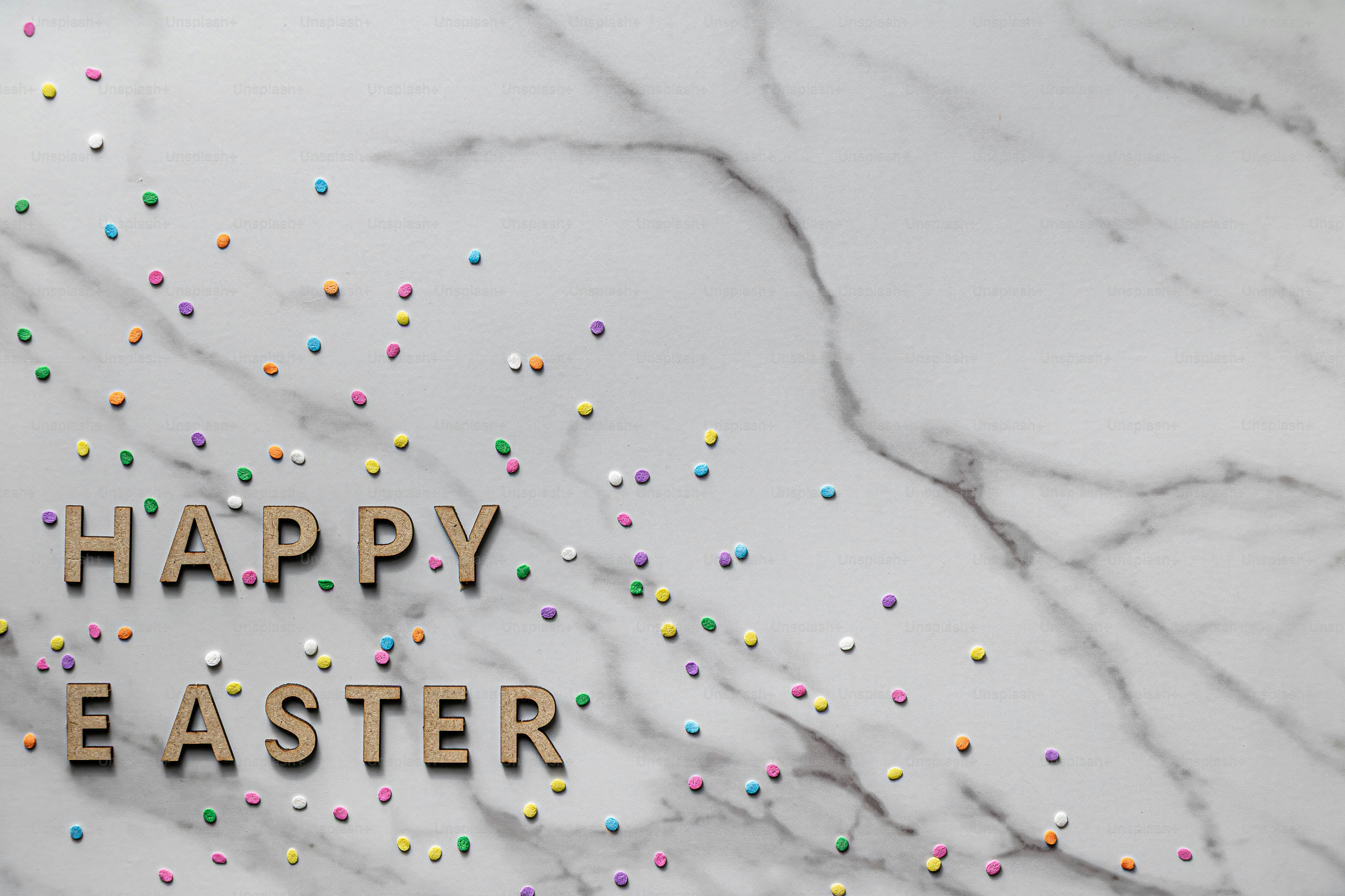 Feliz texto de Pascua con coloridos esparpaderos sobre mármol