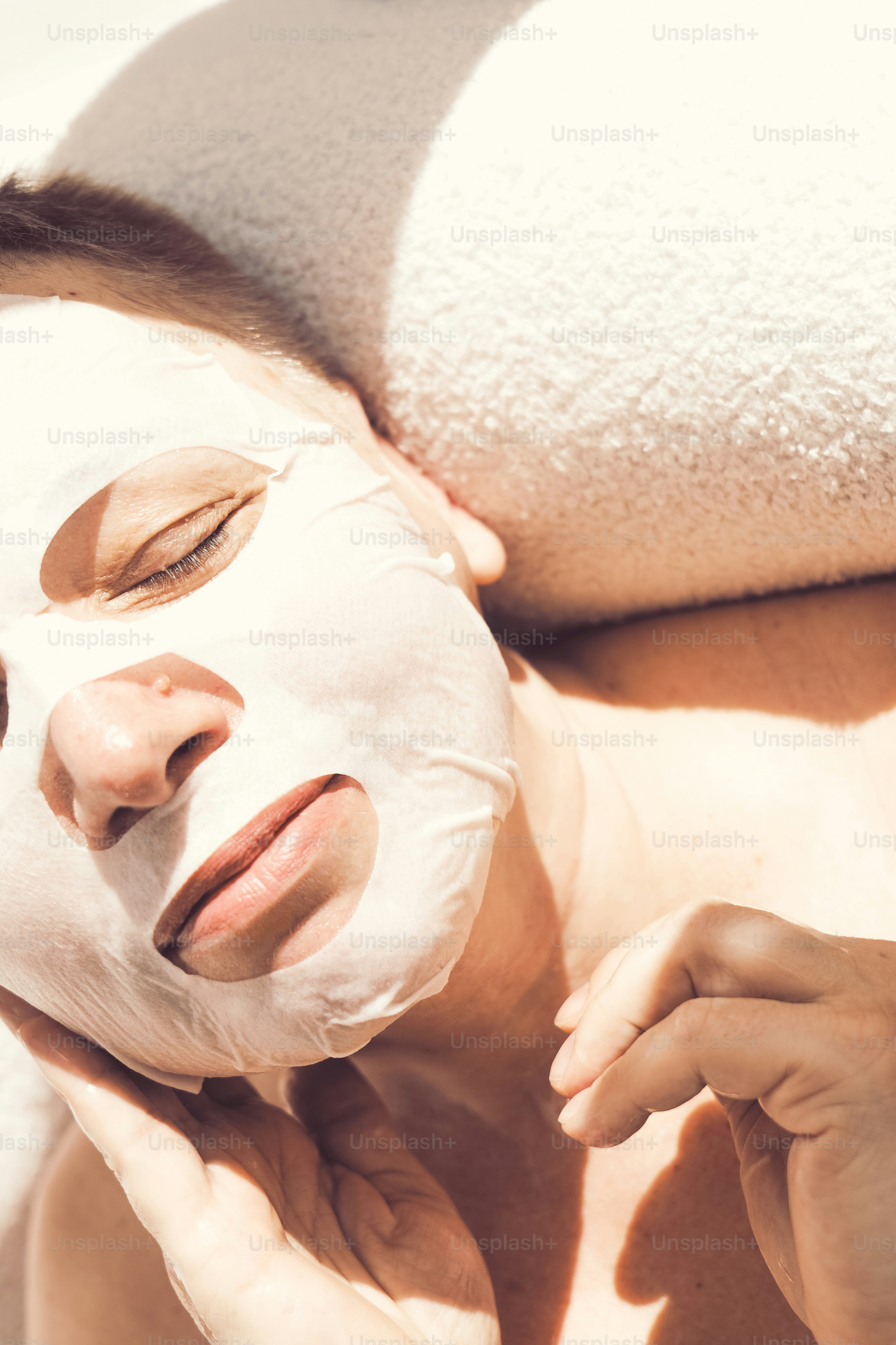 Woman with a facial mask relaxing with eyes closed.