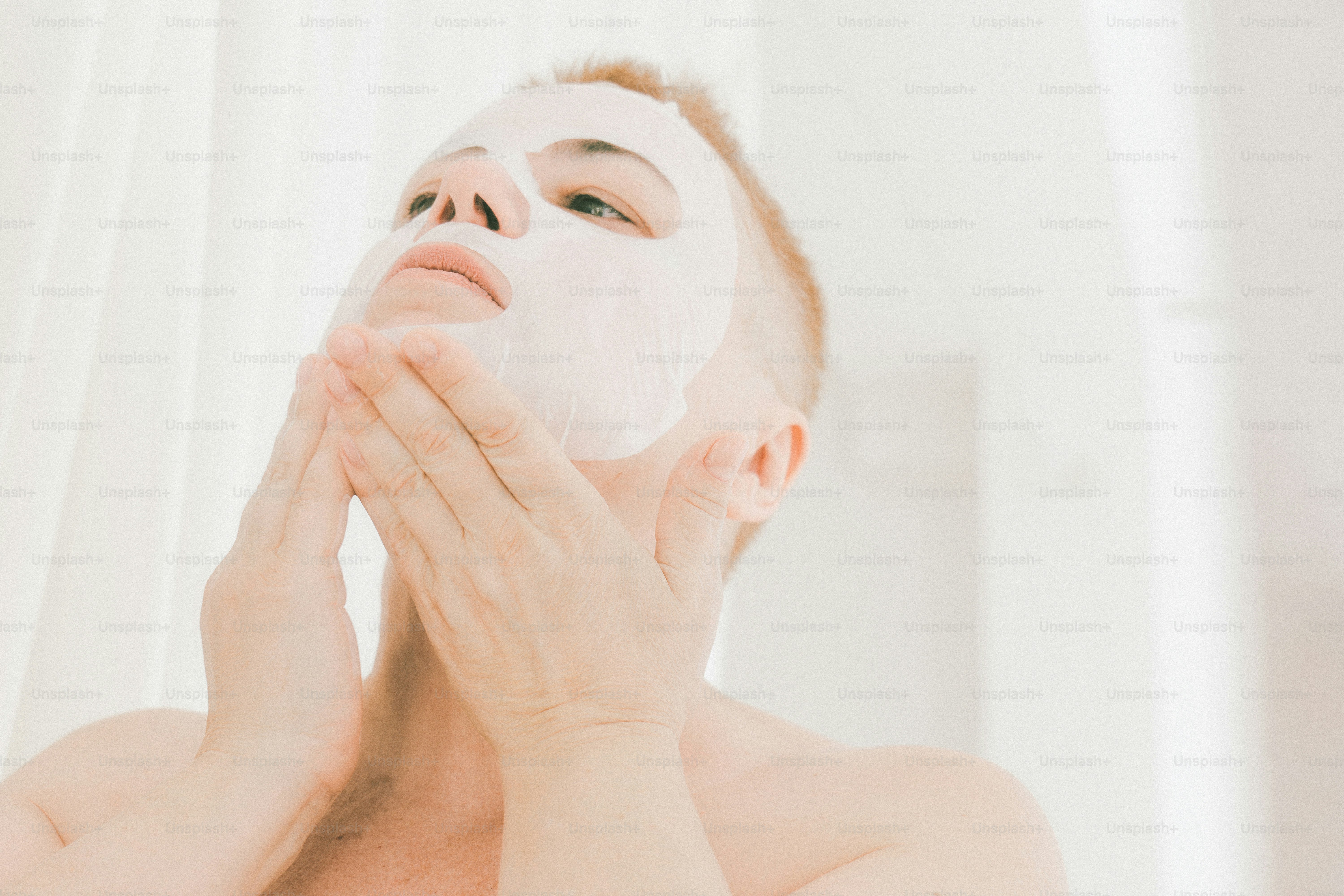 A young man applying a facial mask