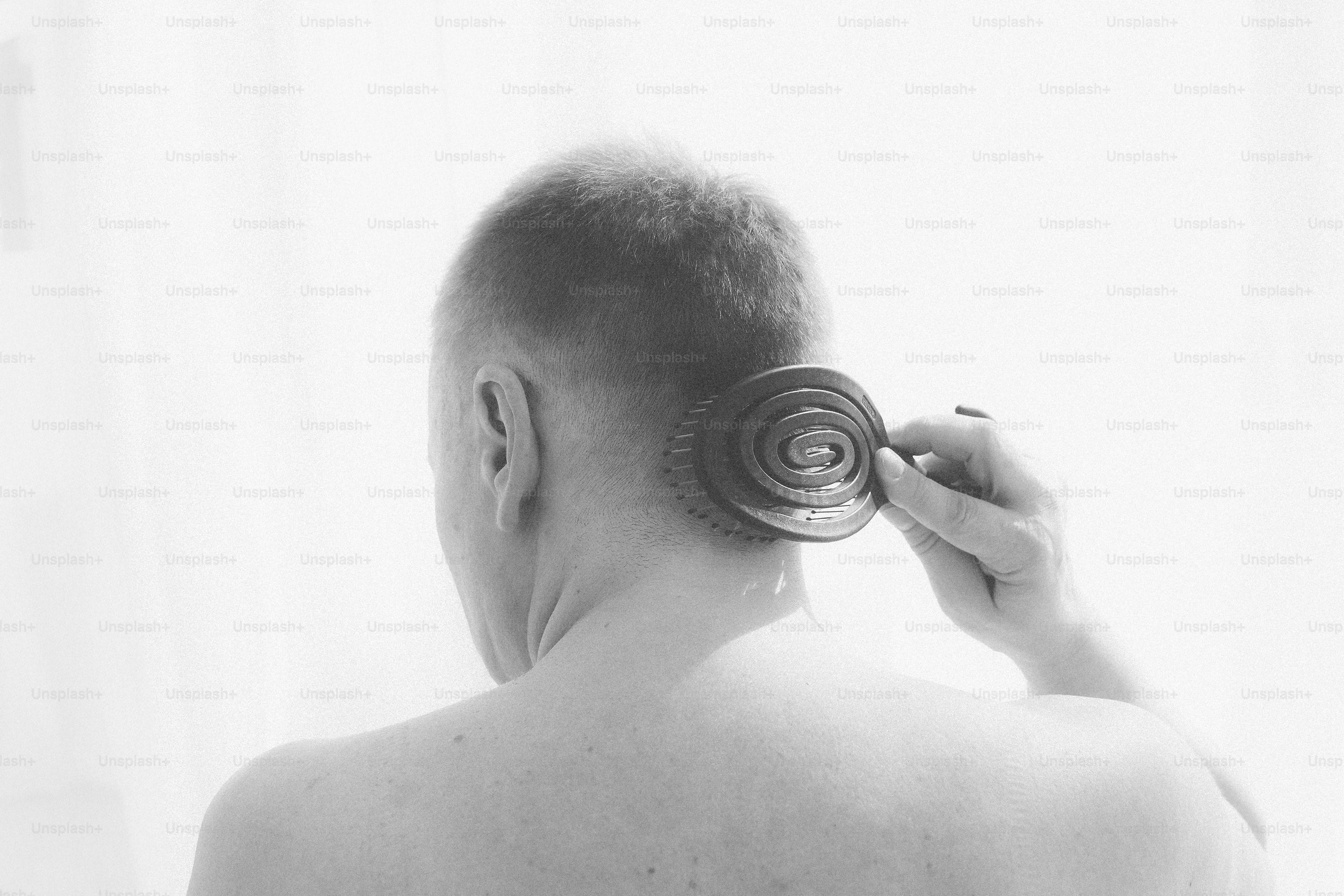 Person using a circular comb on head.