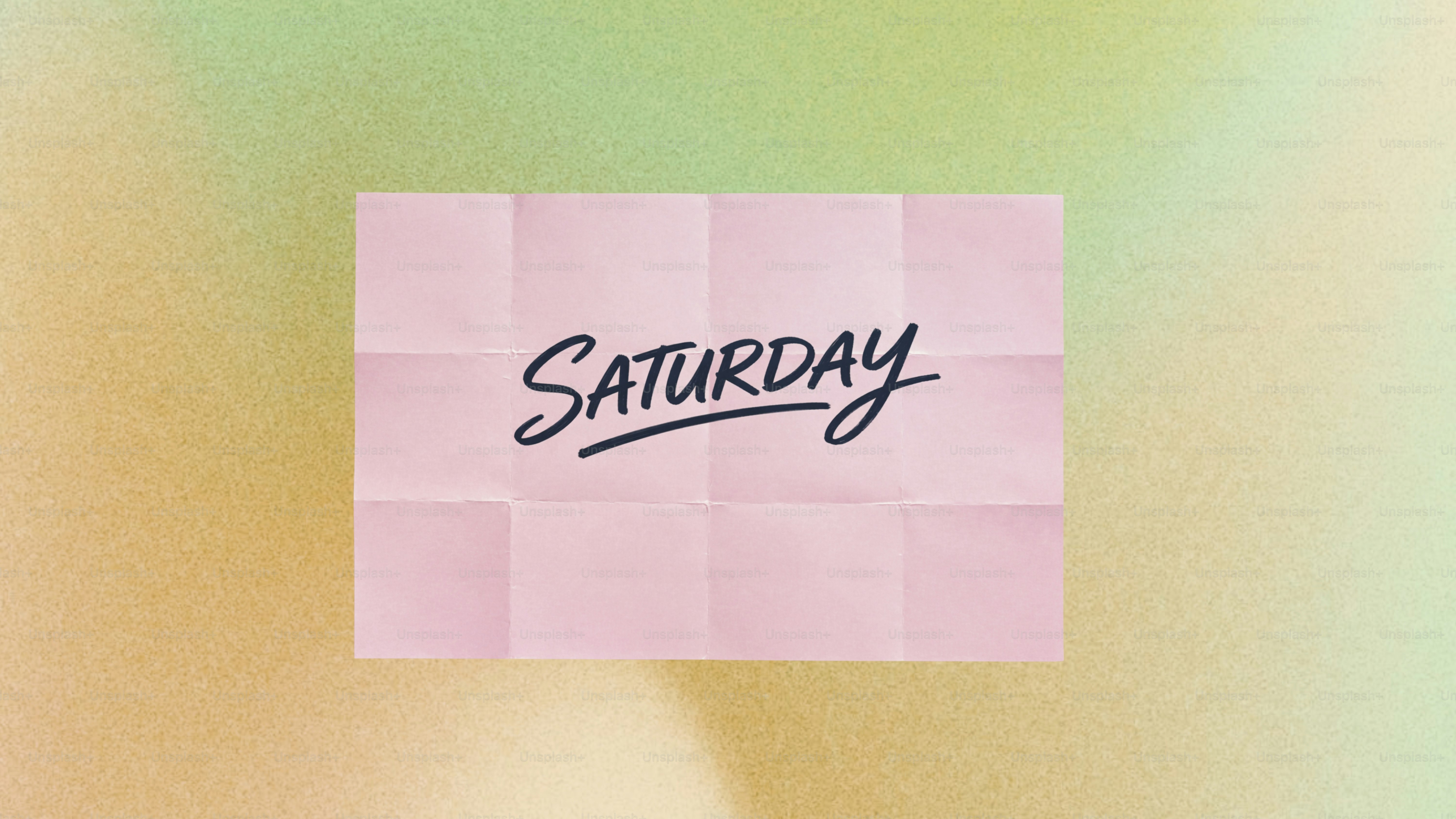 The word saturday written on pink paper