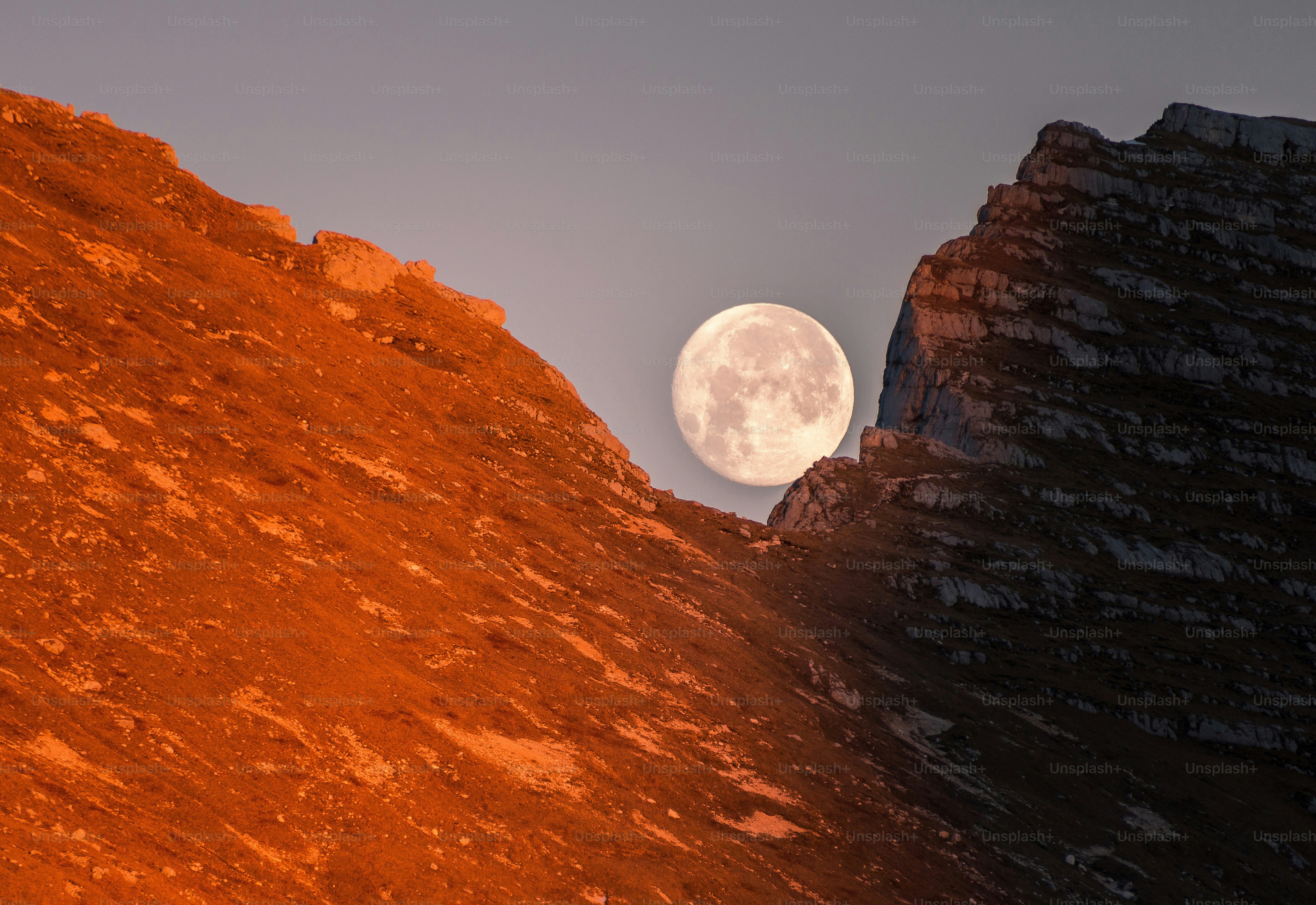 Full moon rising between two rocky mountain peaks. photo – Space Image ...