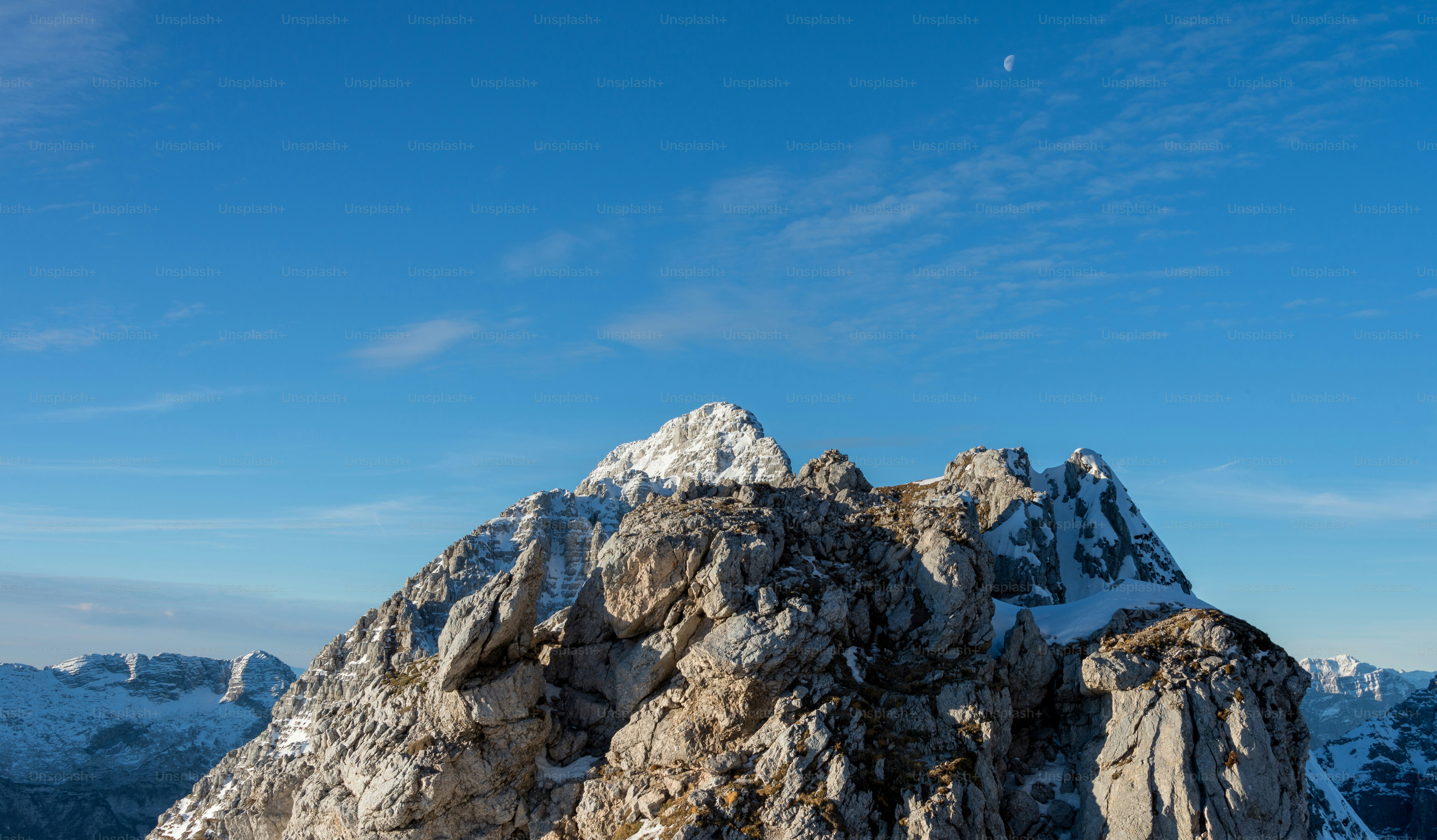 Snow-capped rocky mountain peaks under a clear blue sky