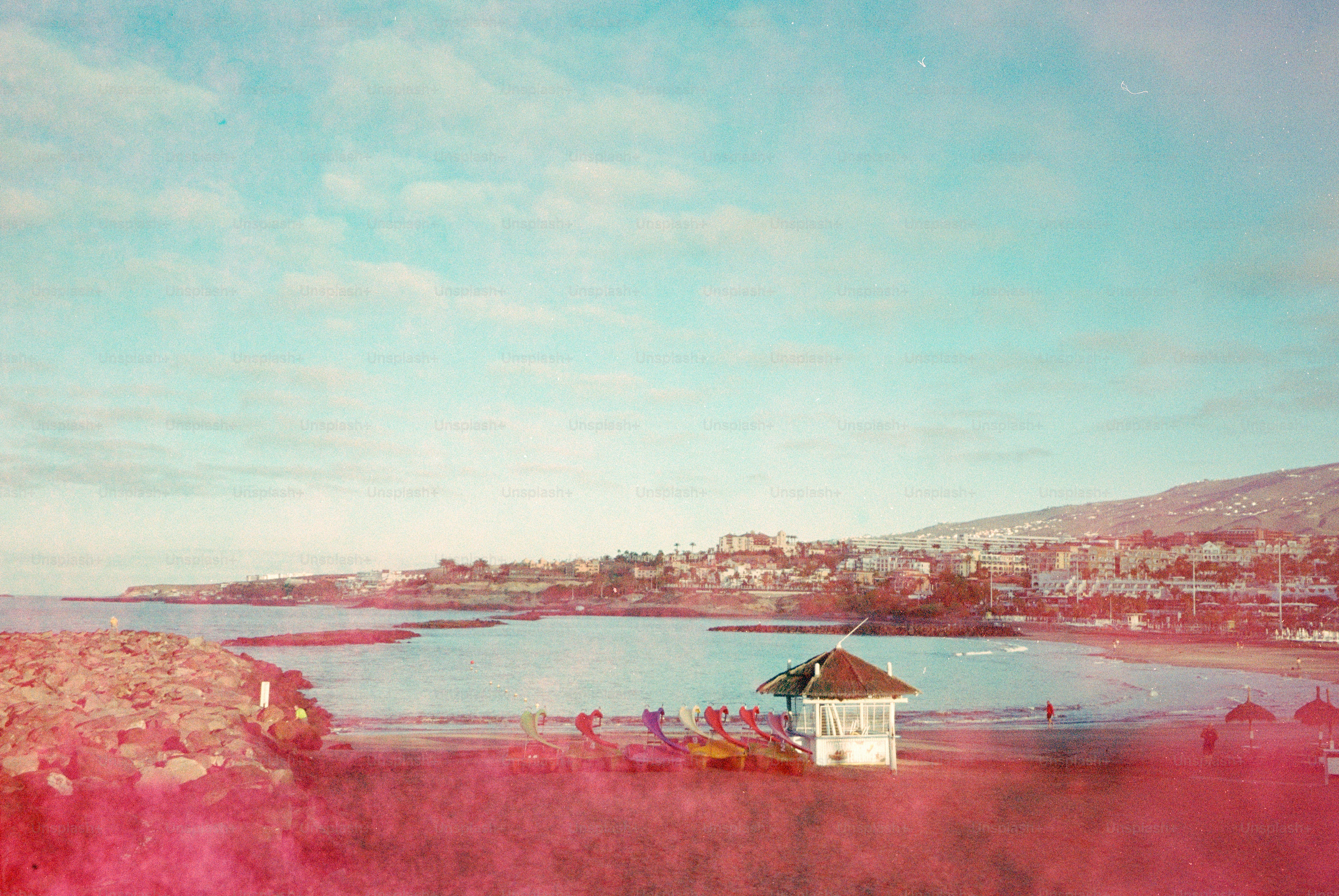 遠くの町があるビーチにある小さな白い建物