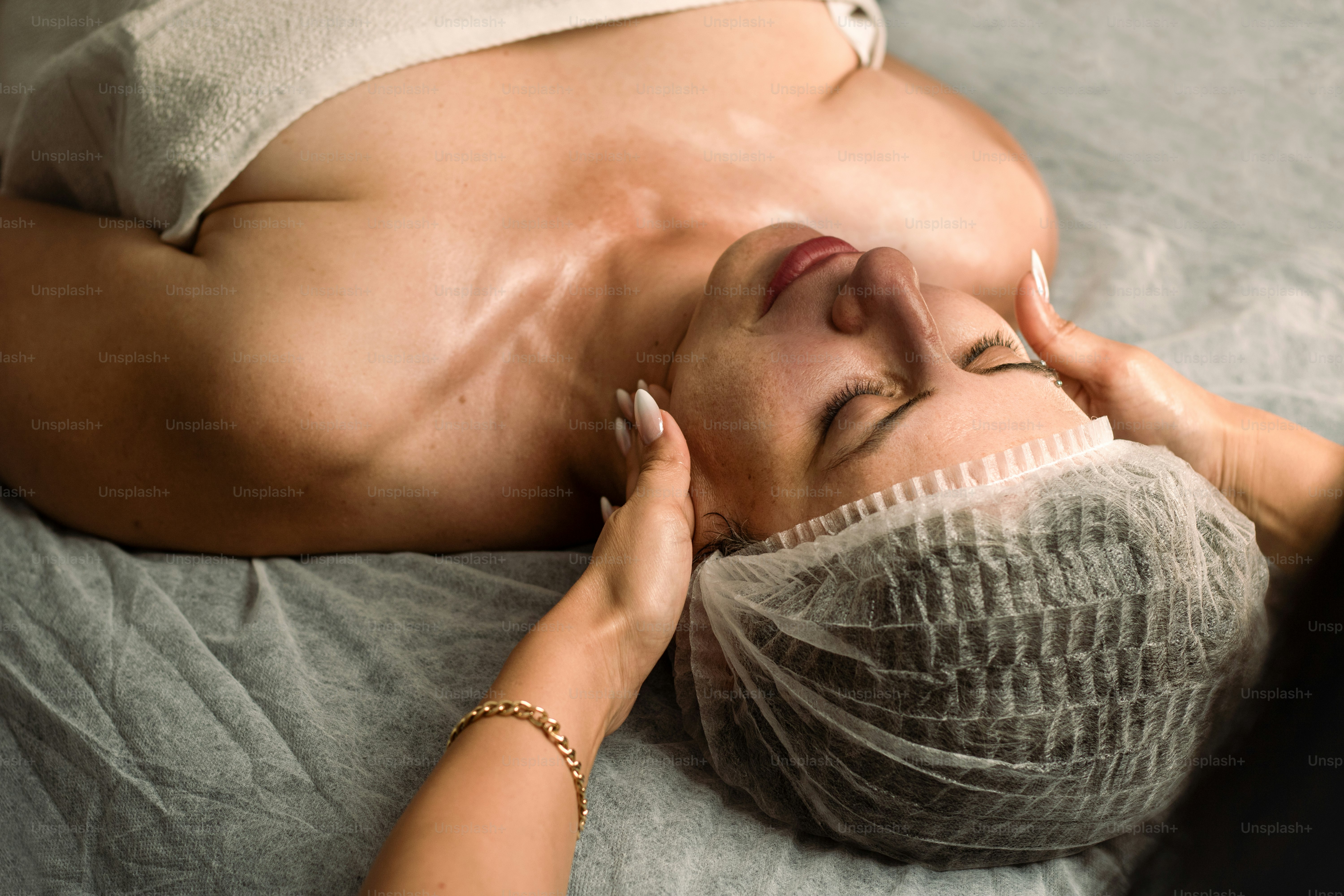 Frau erhält eine Gesichtsmassage mit geschlossenen Augen.