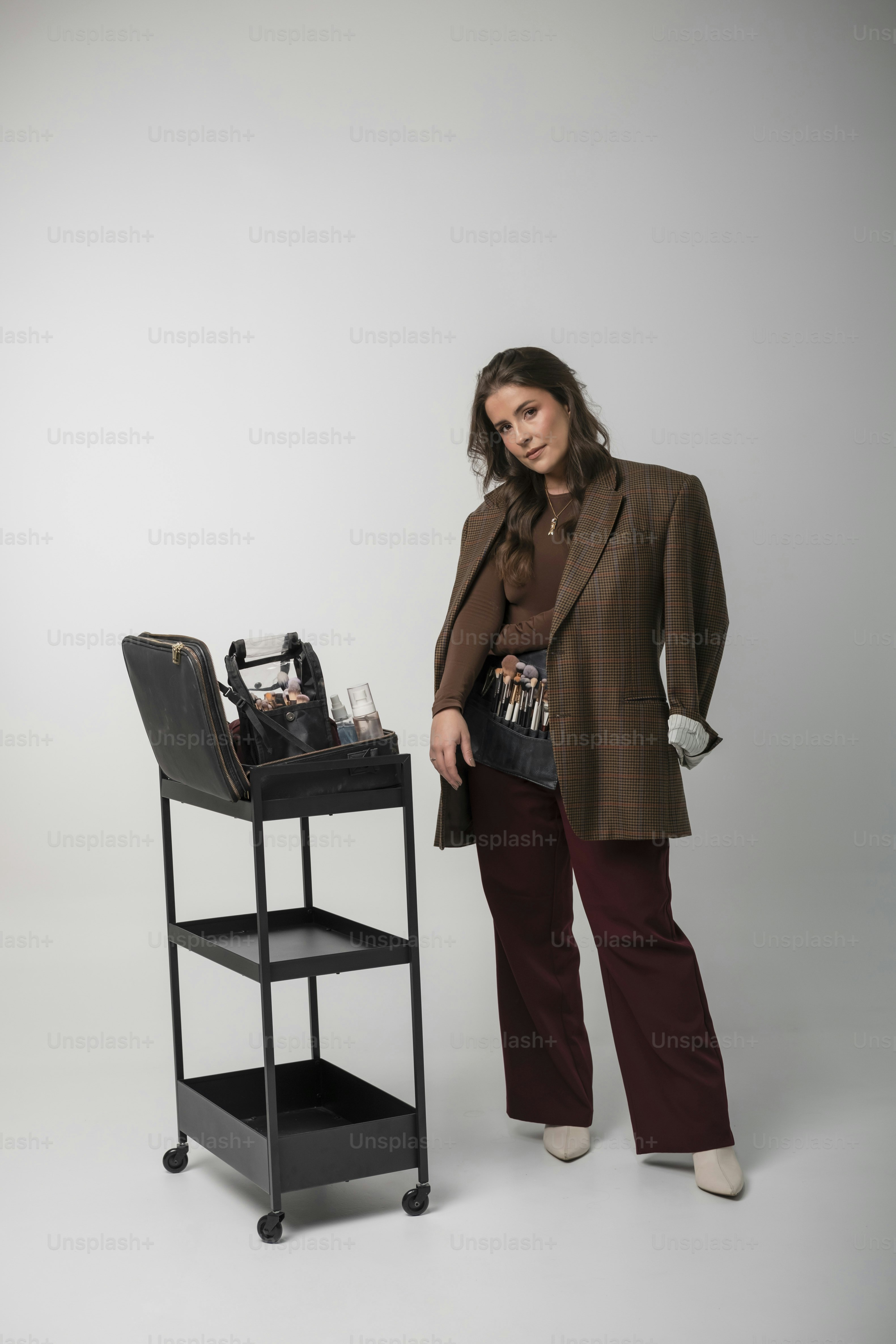 Woman in blazer with makeup artist kit on cart