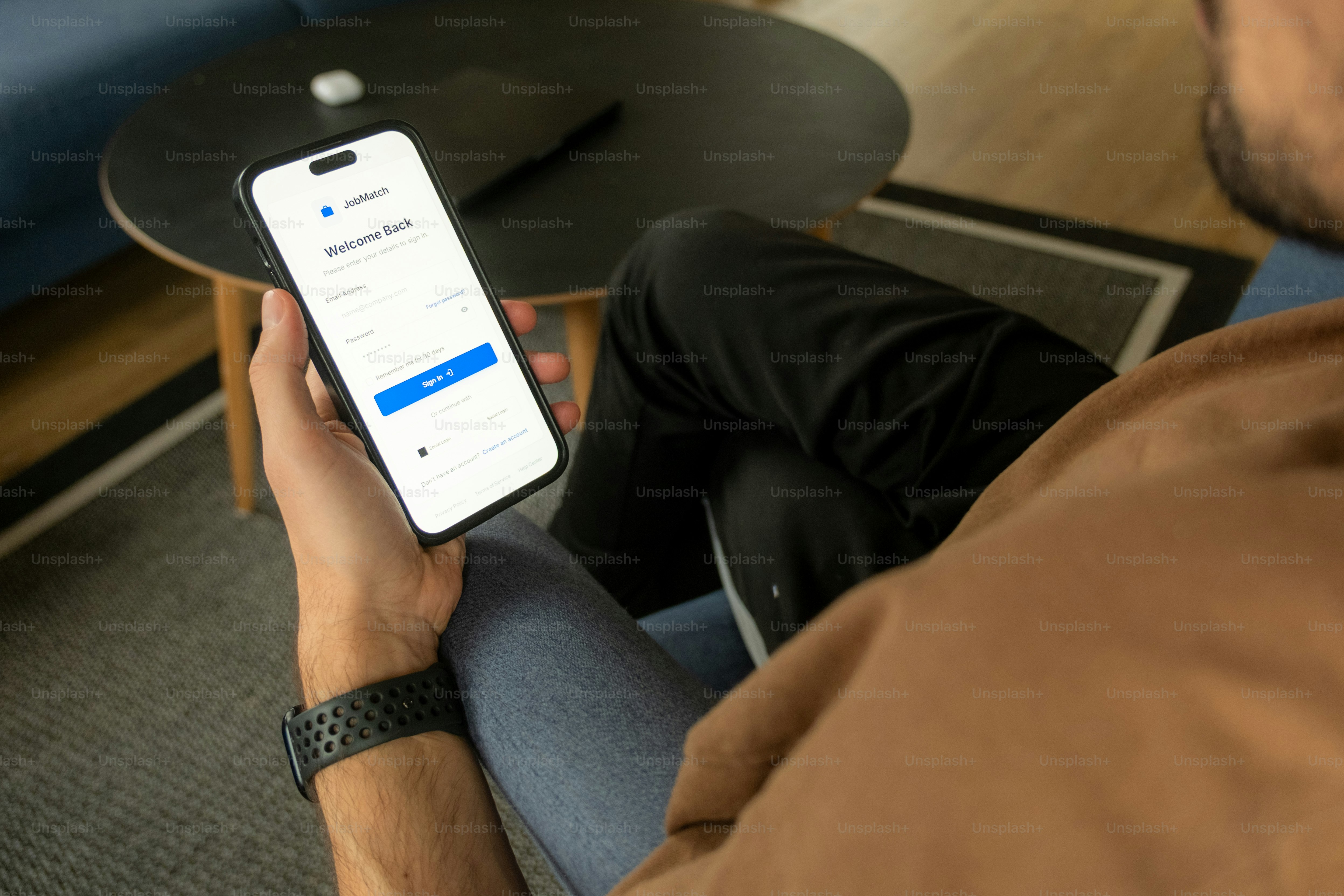 ログイン画面を開いた状態でスマートフォンを持つ男性