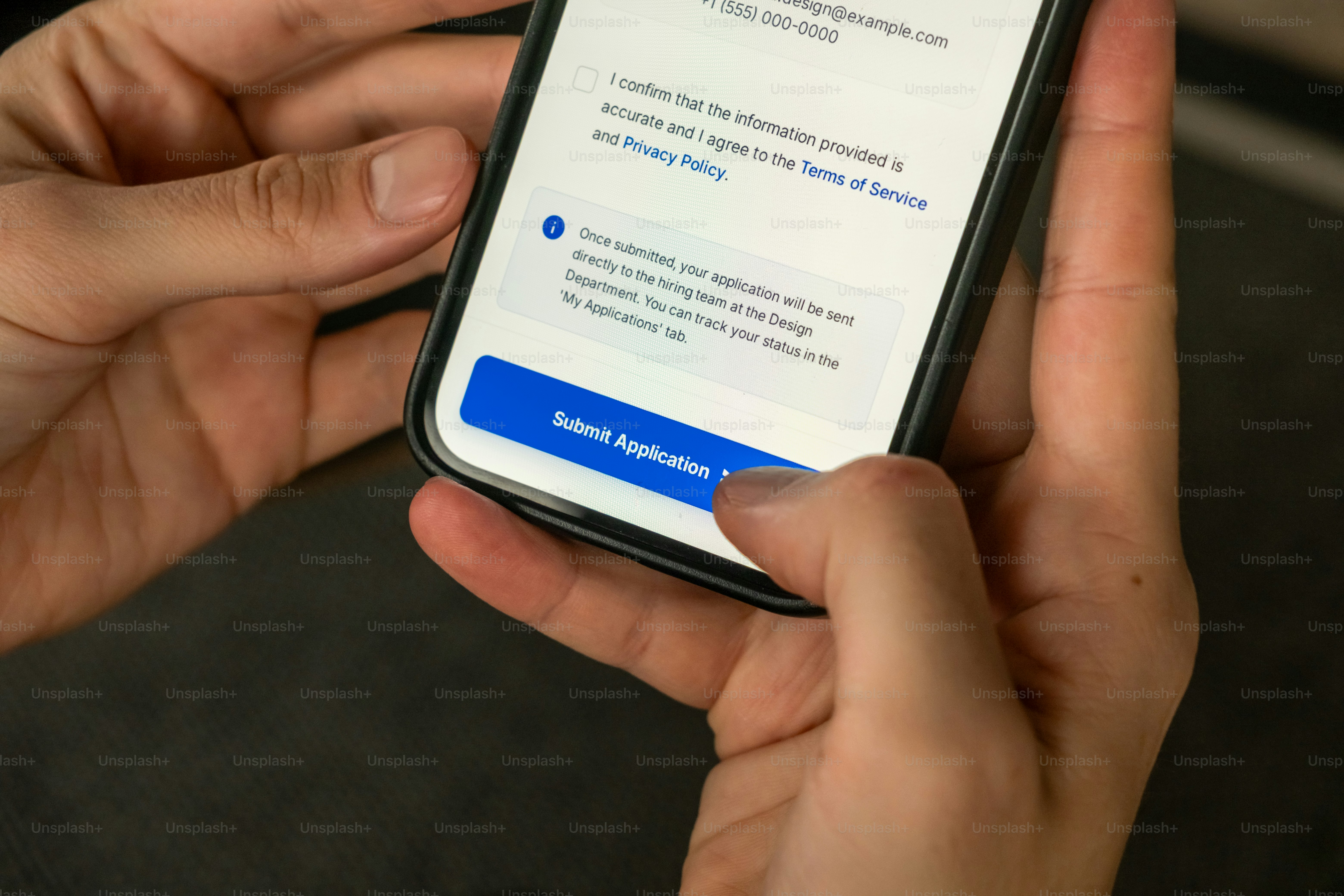 スマートフォンを使って申請を提出する手。