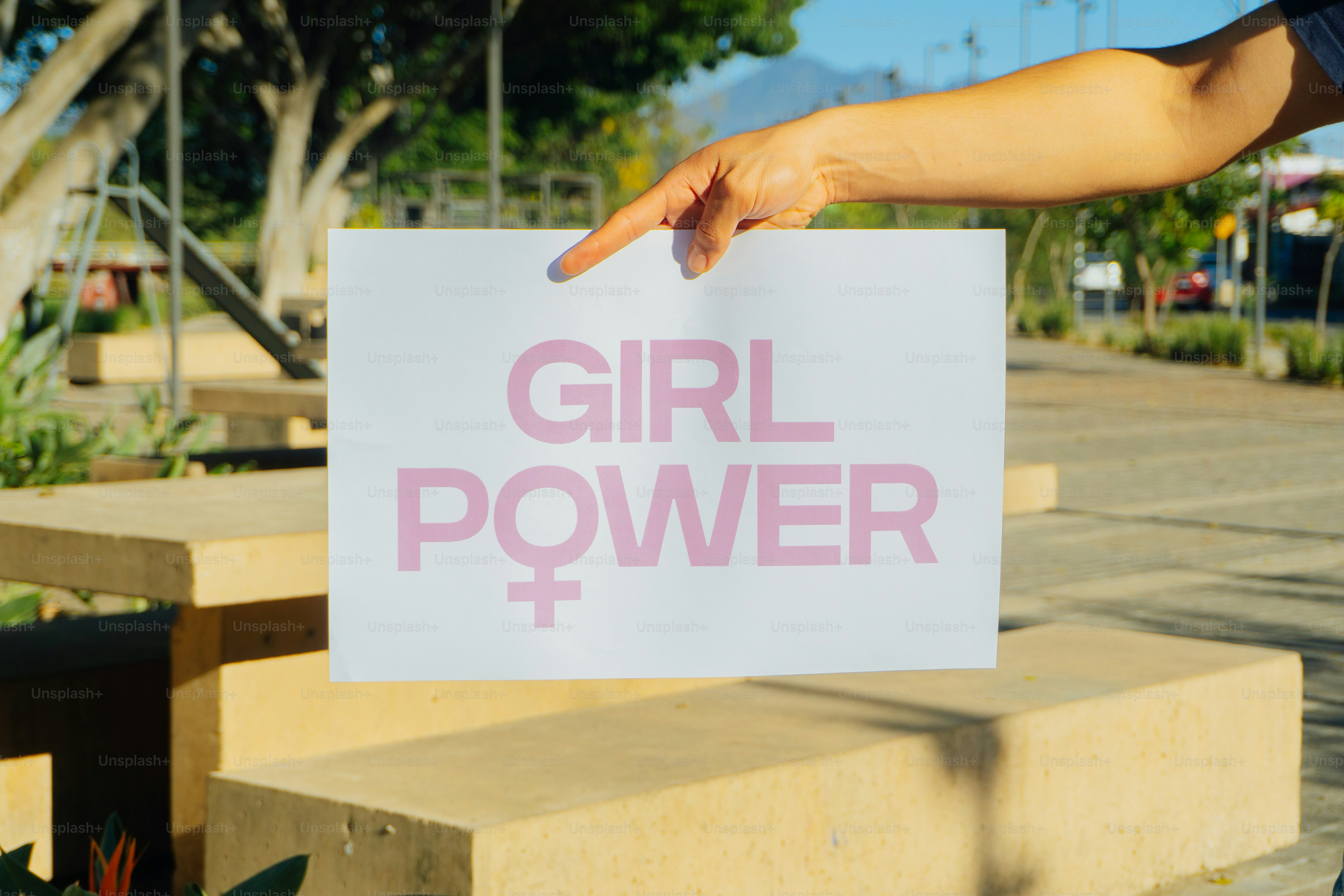 Une main tient un panneau sur lequel il est écrit « girl power ».