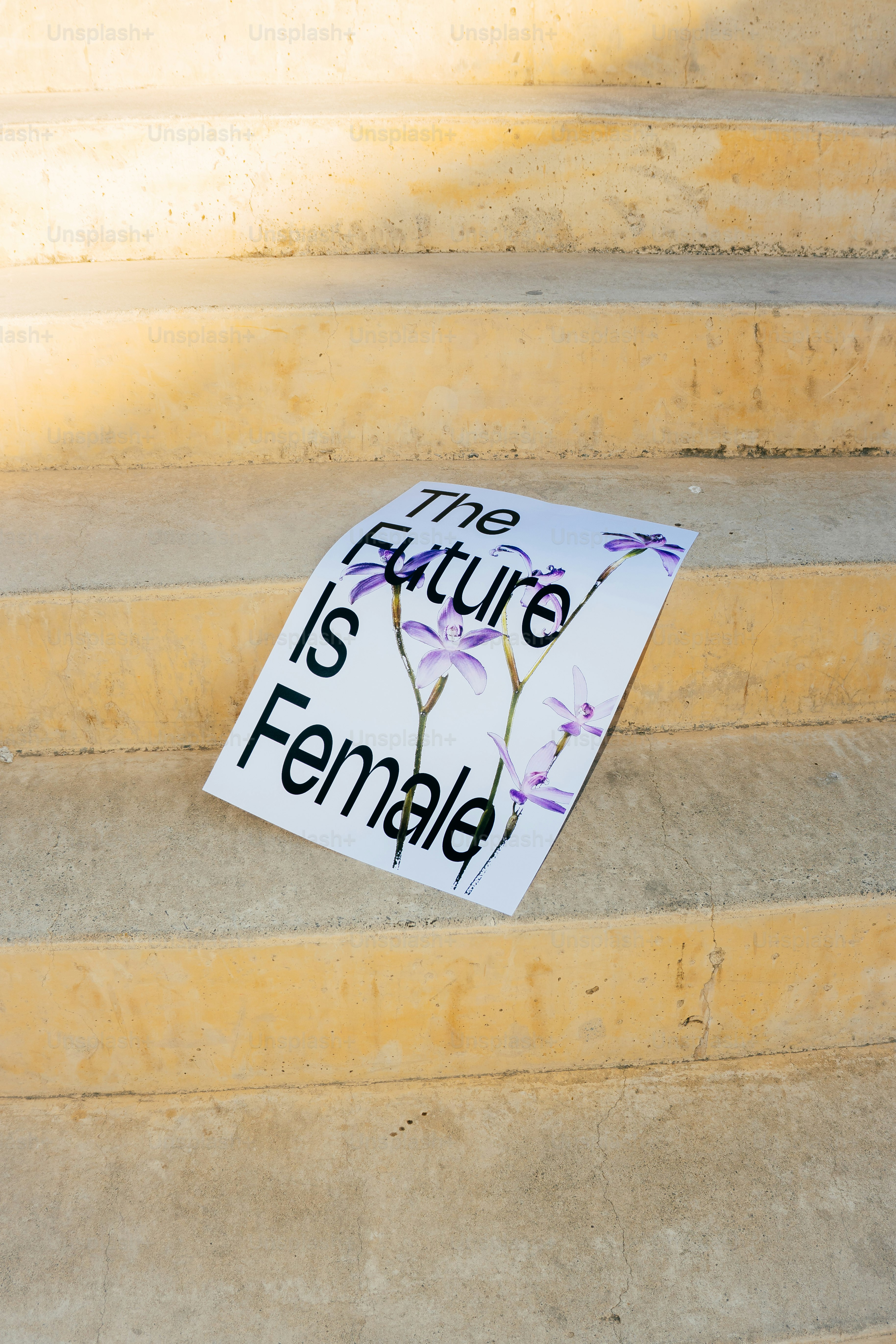 Auf einem Schild steht 'Die Zukunft ist weiblich' auf der Treppe.