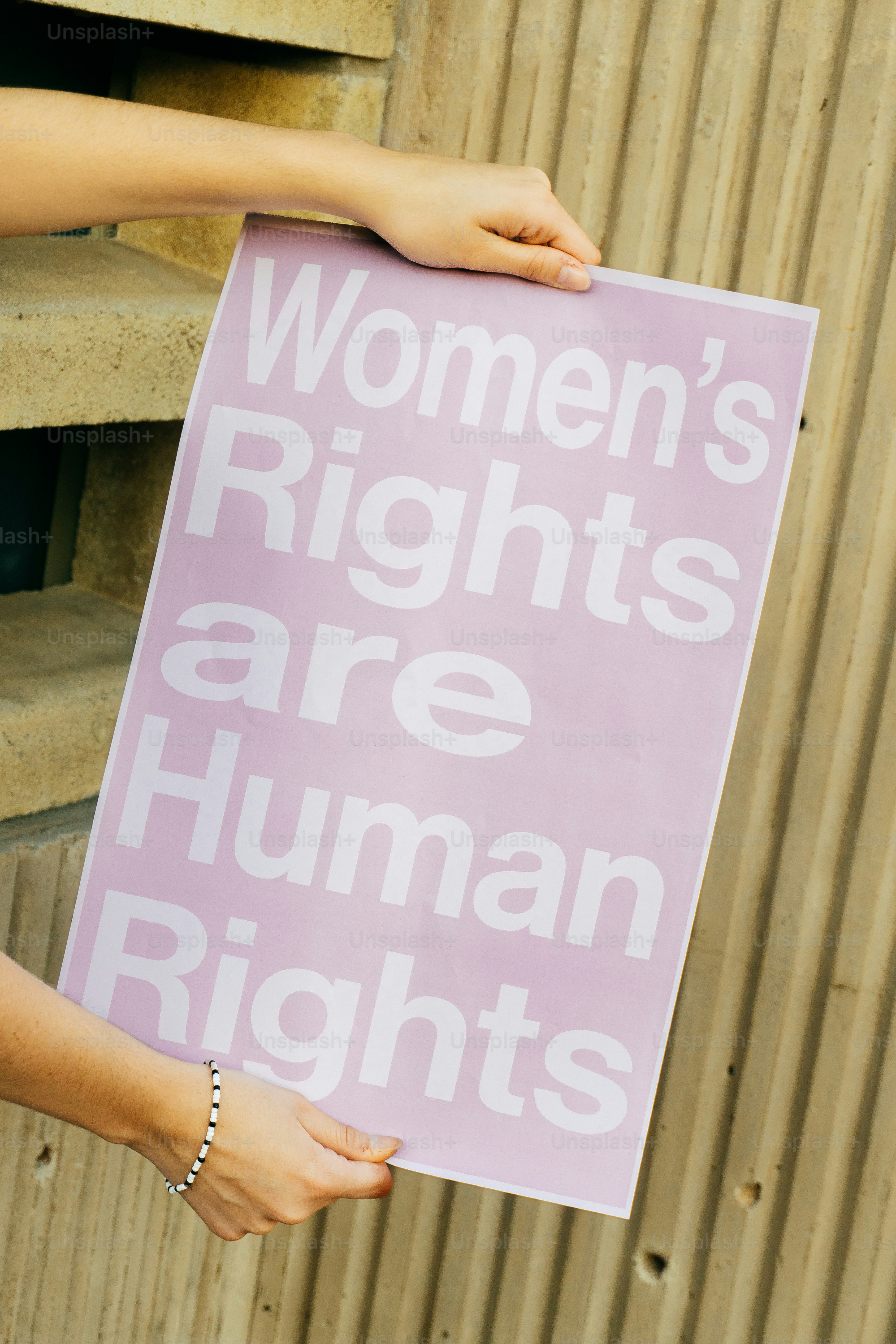 Hands hold a sign stating women's rights are human rights. photo ...