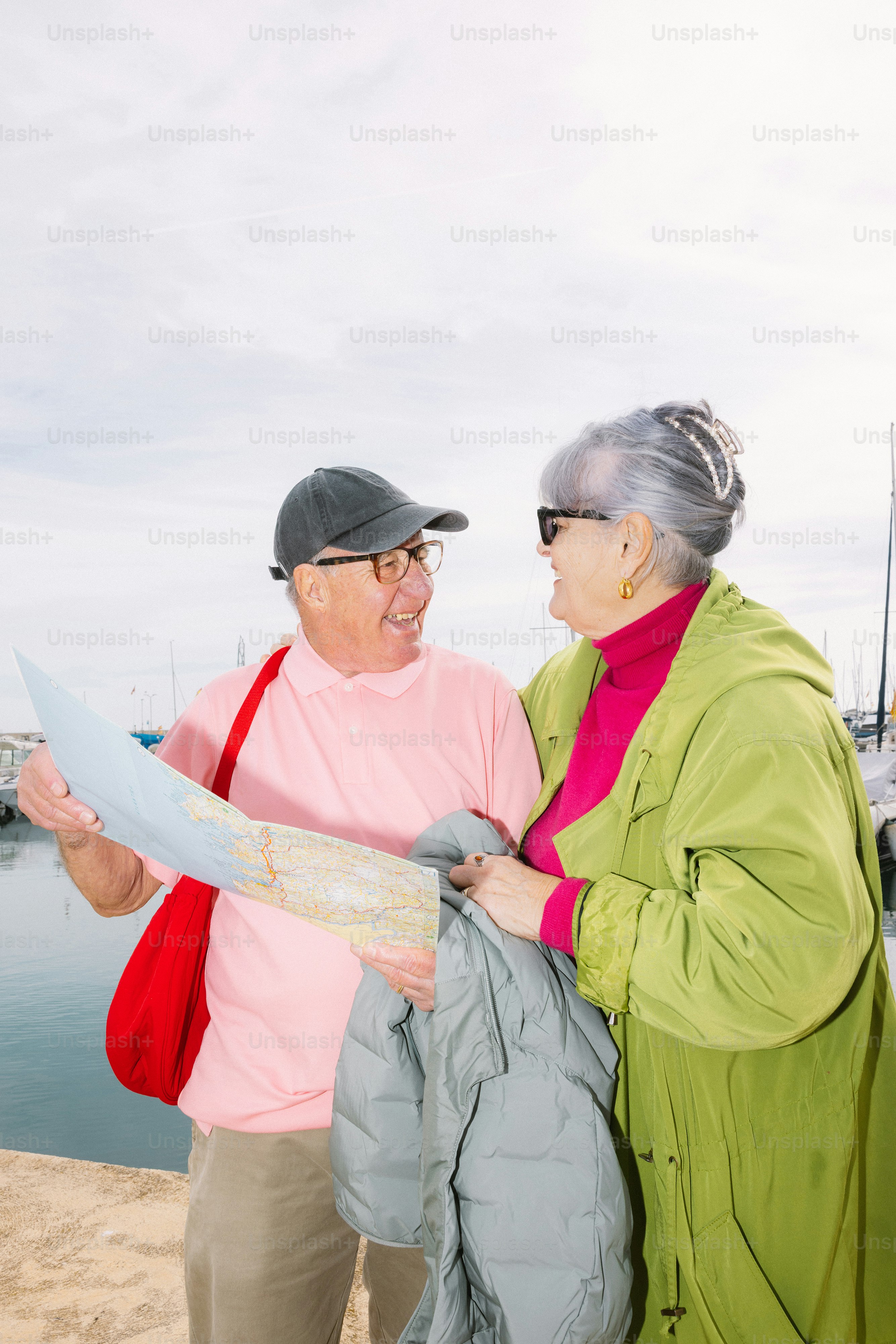 Casal idoso olhando para um mapa à beira da água